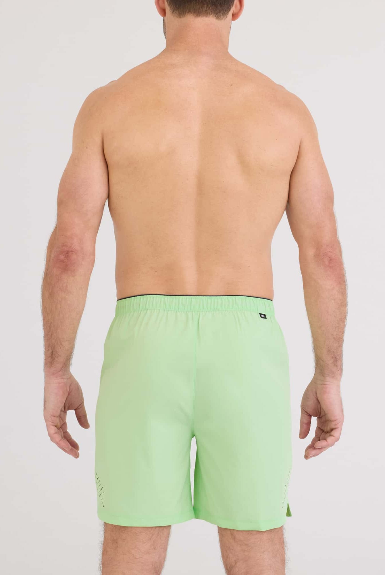 Back view of a man wearing Power Moves 2N1 Short 7 in bright green, showcasing the lightweight and stylish design.