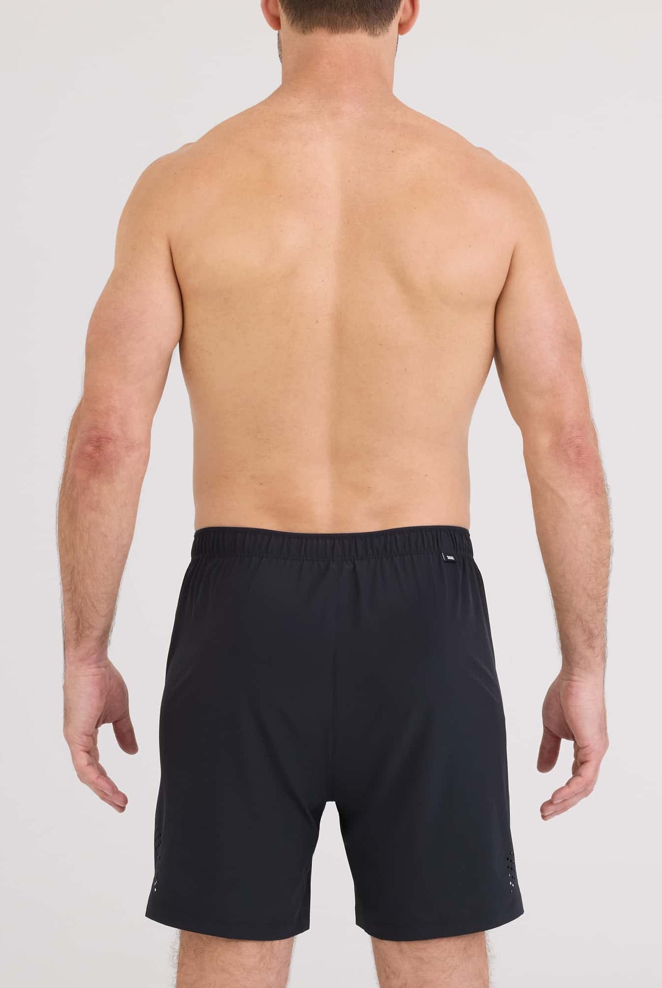 Back view of a man wearing Power Moves 2N1 Short 7 from SAXX, showcasing the black sporty design.