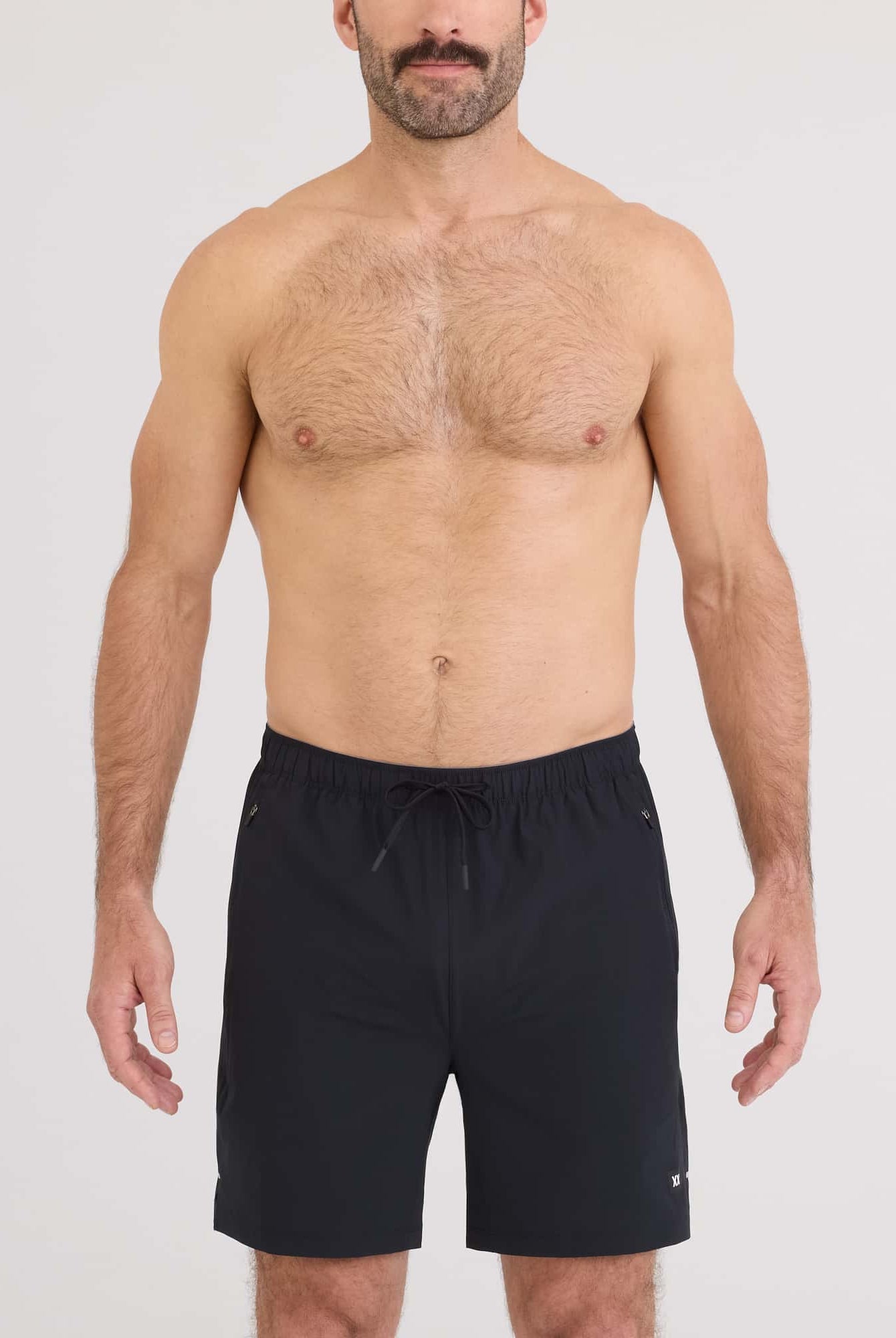 Man wearing Power Moves 2N1 Short 7 in black, showcasing comfort and performance for runners and gym enthusiasts.