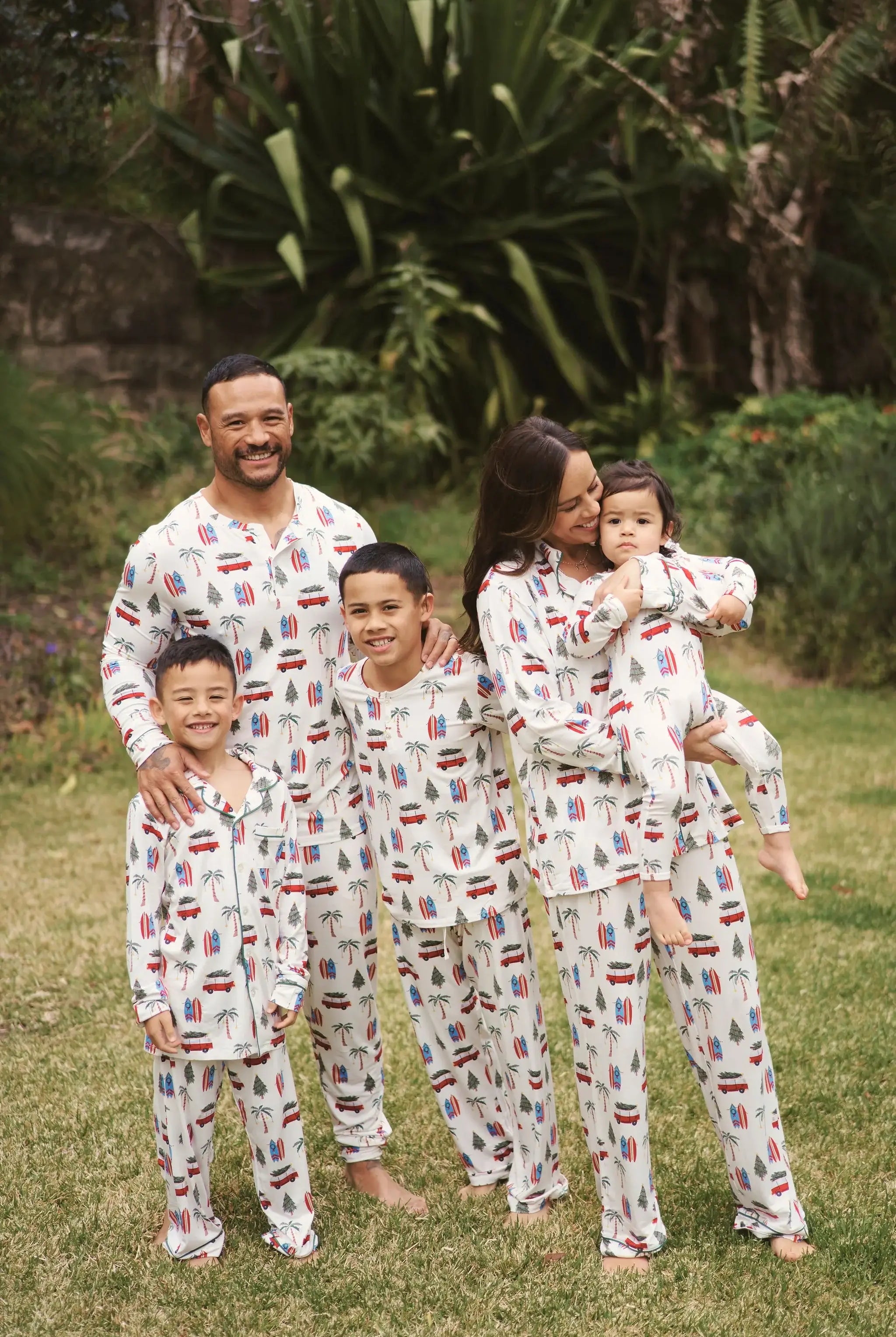 Family wearing Cali Beachy Christmas Men's Bamboo Henley Jogger Set in a tropical garden.