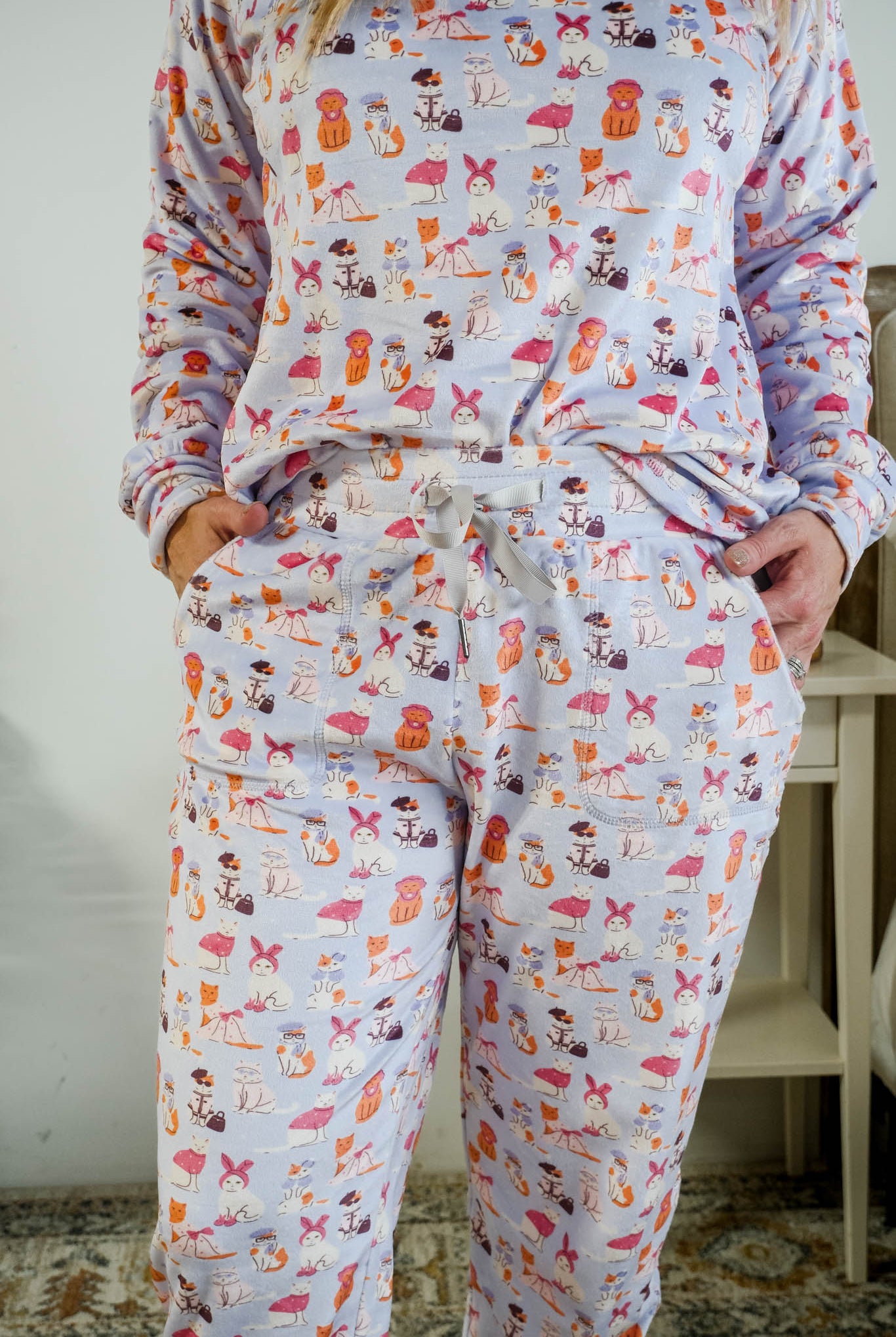 Showing the drawstring detail and pockets on the Miranda Nic women's purple velour long sleeve top and jogger pants set featuring Catwalk Kitties cat print - Cloud Nine Pajamas