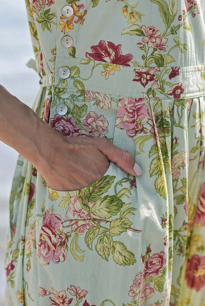 April Cornell Milene Cotton Pinafore Midi Dress Sage Green with Hand-Crochet Neckline showing the pockets and side button details