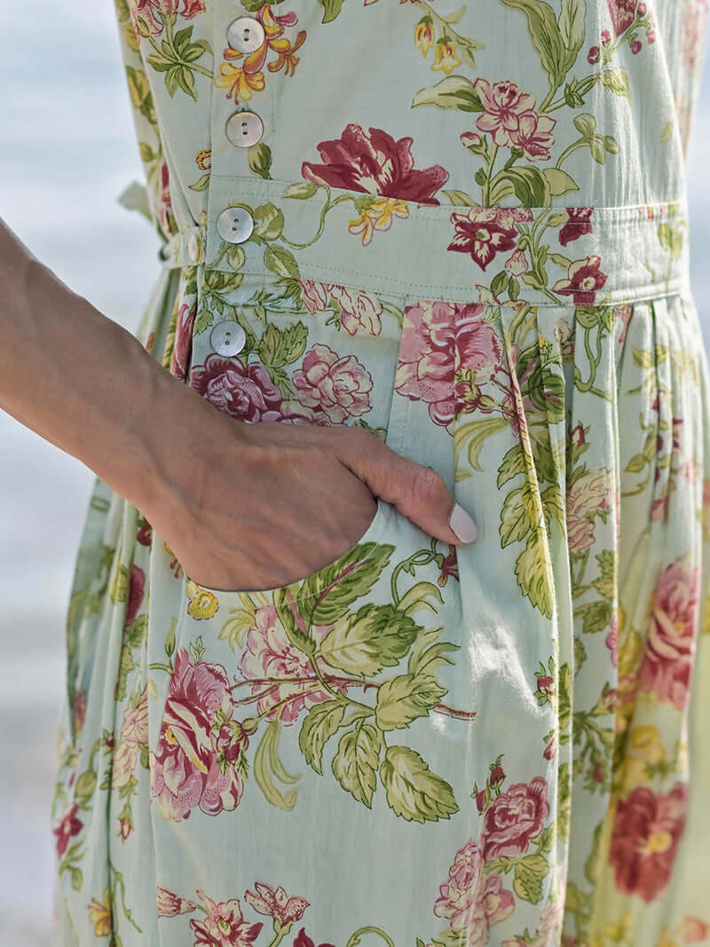 April Cornell Milene Cotton Pinafore Midi Dress Sage Green with Hand-Crochet Neckline showing the pockets and side button details