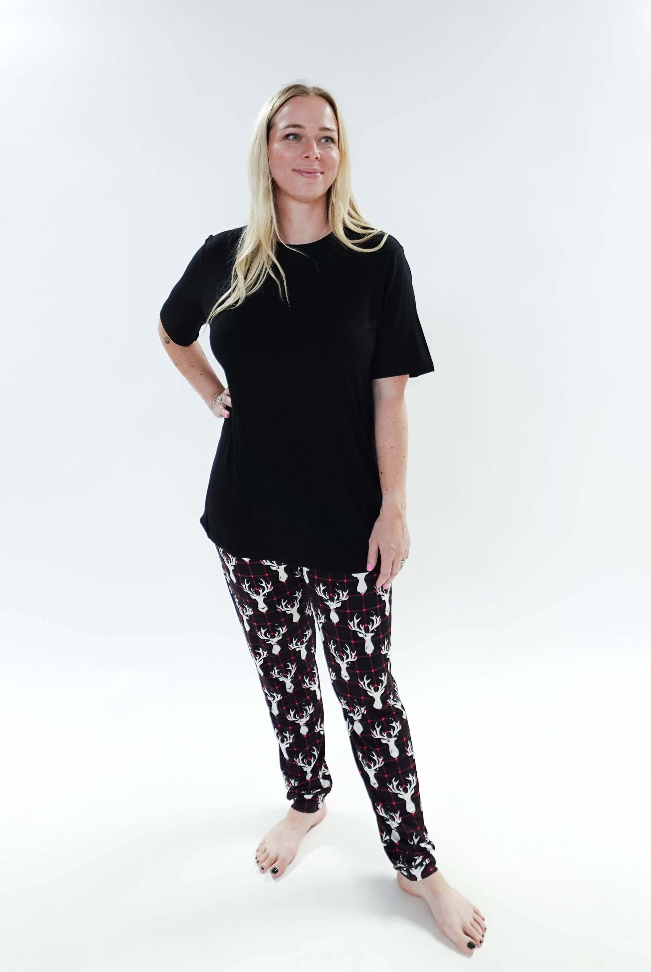 Woman wearing Deer Plaid Unisex Bamboo Jogger and a black top, showcasing comfort and style in sleepwear.