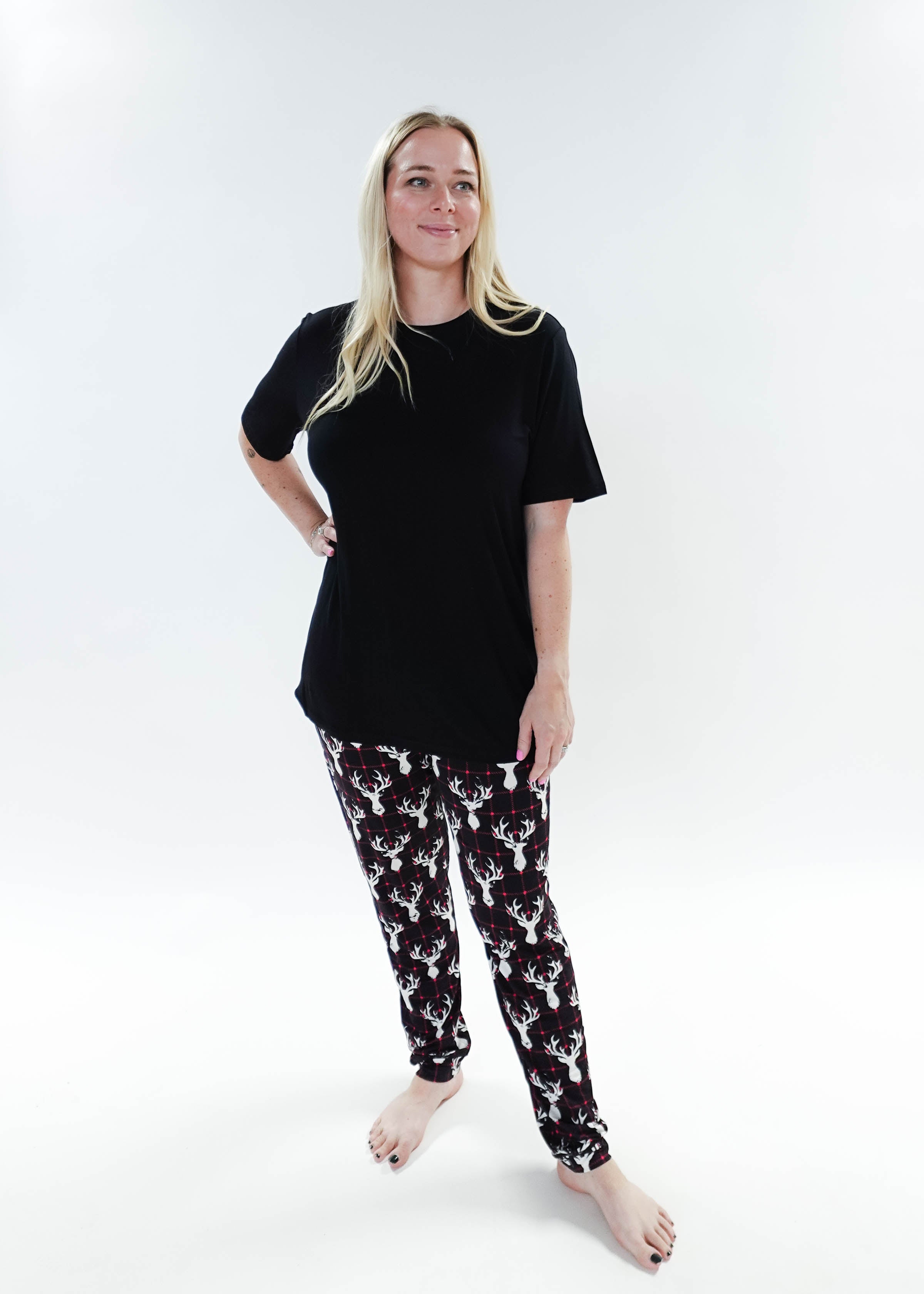 Woman wearing Deer Plaid Unisex Bamboo Jogger and a black top, showcasing comfort and style in sleepwear.