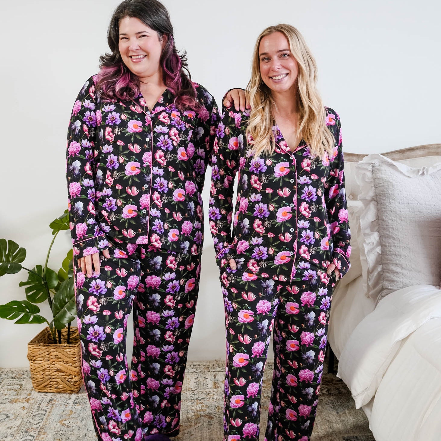 Georgia Rylan women's bamboo long sleeve button-up top and straight-leg pajama pants in Dreamy Blooms black floral print - Cloud Nine Pajamas on models in a bedroom setting