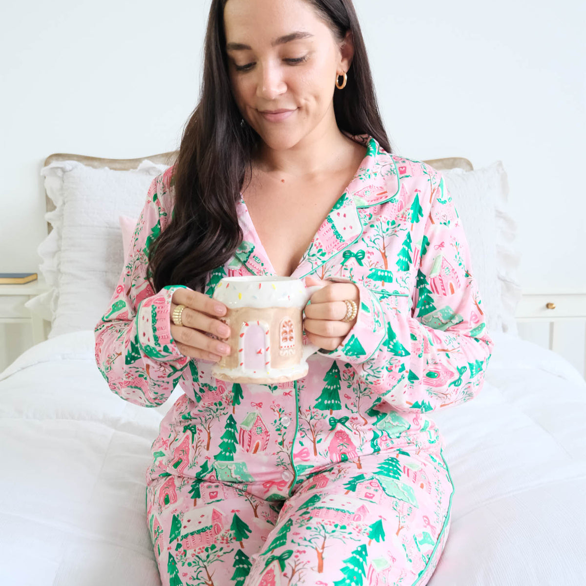 Georgia Rylan Sugar Plum Dreams gingerbread house print close-up sitting model on bed — Cloud Nine Pajamas Edmonton