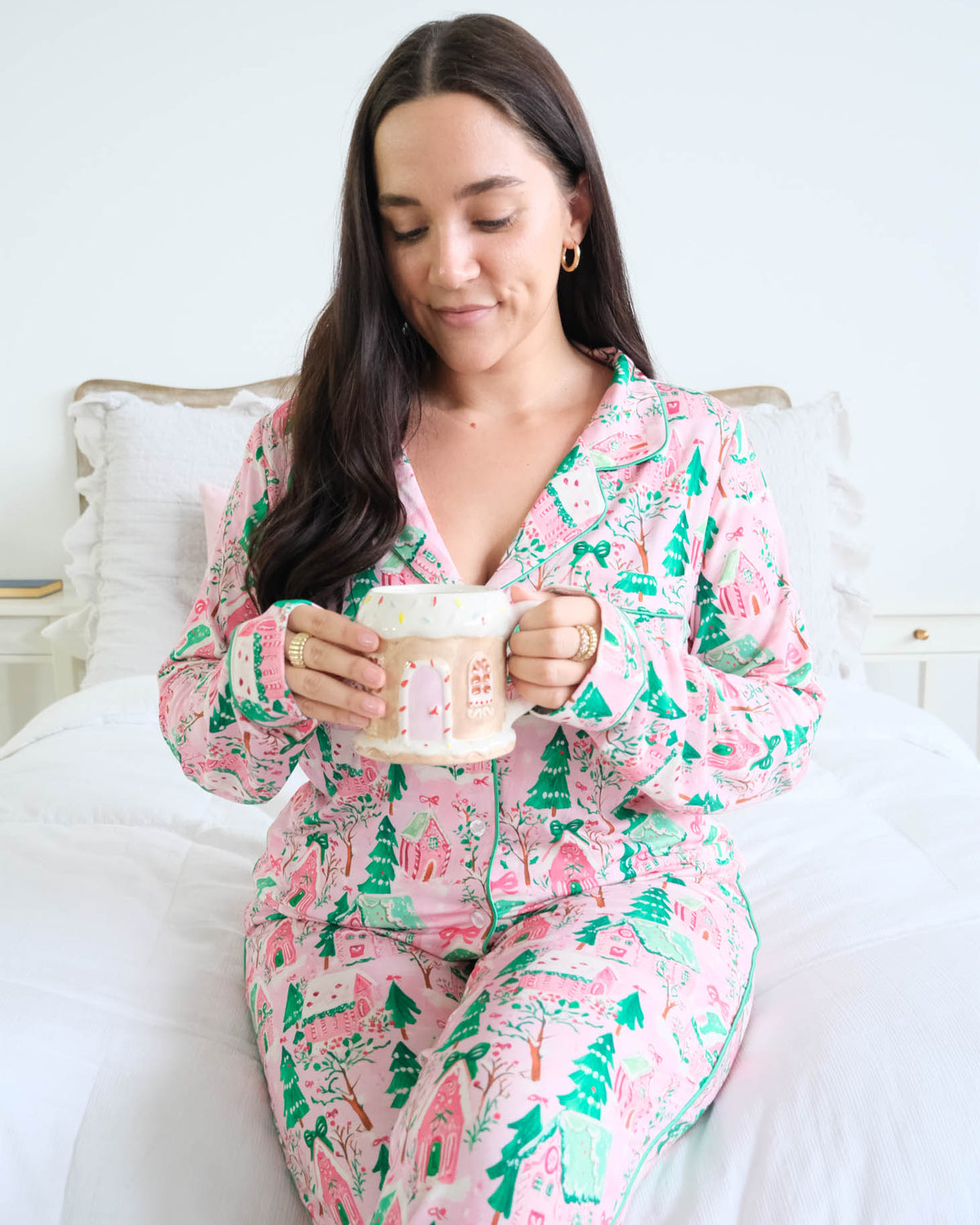 Georgia Rylan Sugar Plum Dreams gingerbread house print close-up sitting model on bed — Cloud Nine Pajamas Edmonton