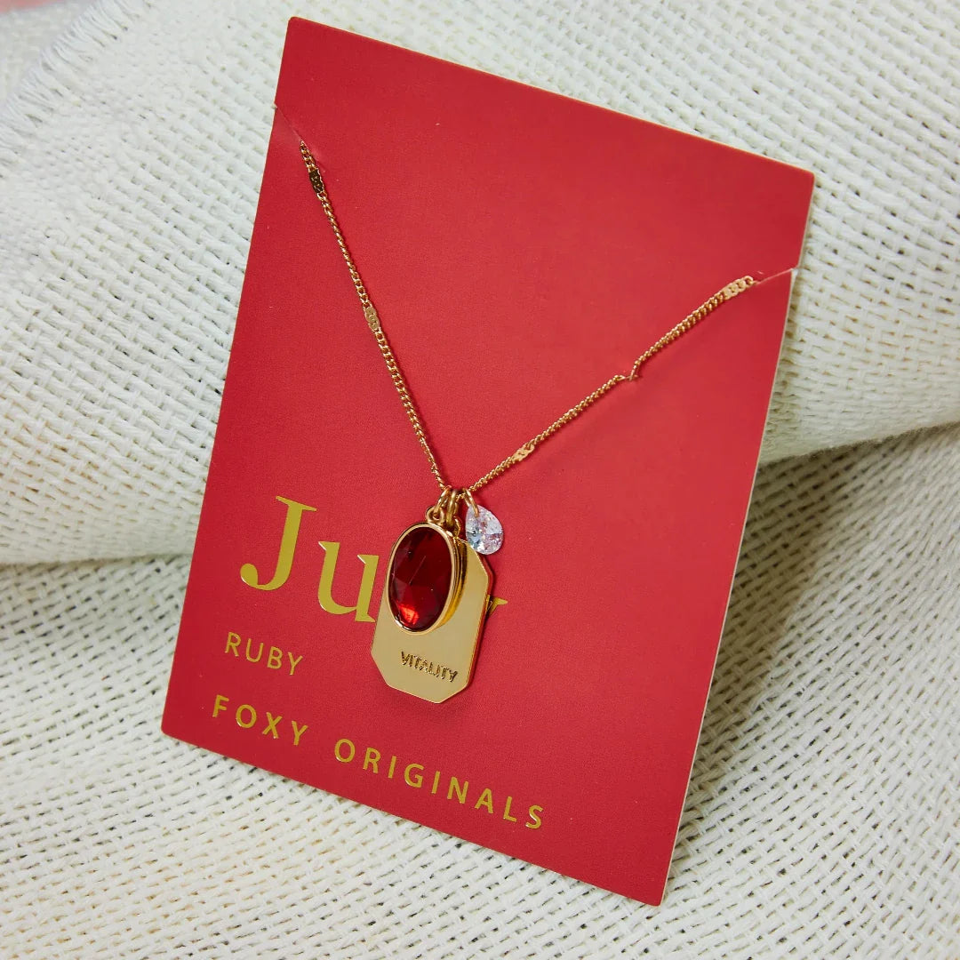 Birthstone Charm Necklace in 14k Plated Gold featuring a ruby stone, labeled 'Vitality', by Foxy Originals. Birthstone Charm Necklace in 14k Plated Gold for JUNE featuring a ruby stone, labeled 'Vitality', by Foxy Originals.