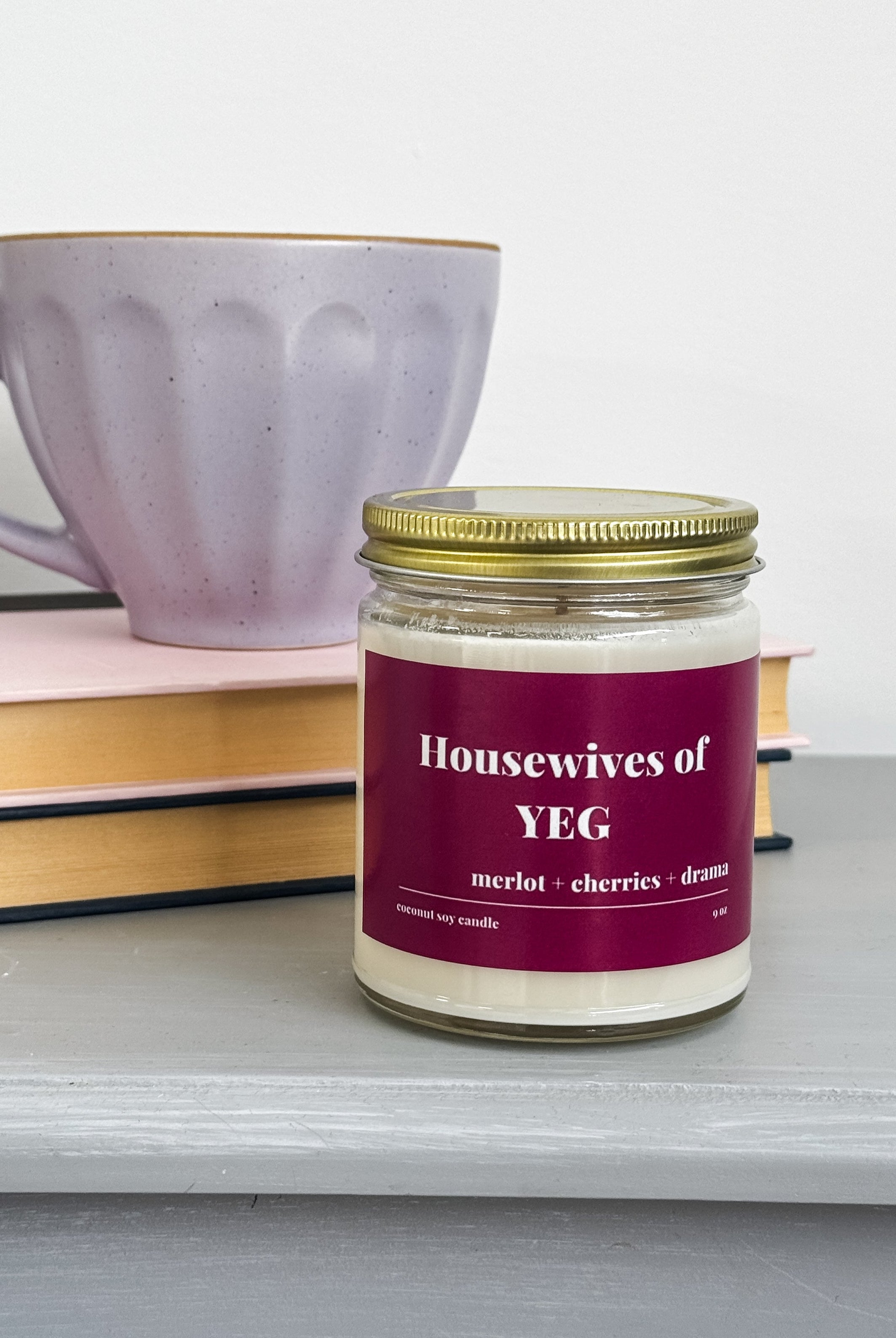 merlot and cherry scented coconut soy wax candle with "Housewives of YEG" label in red