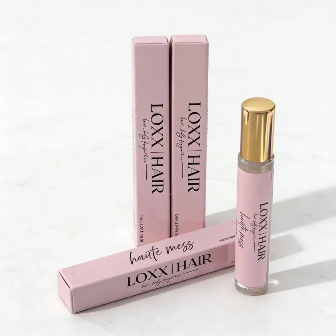 LOXX Haute Mess Hair & Body Fragrance – 10mL travel size with elegant pink packaging and gold cap displayed.