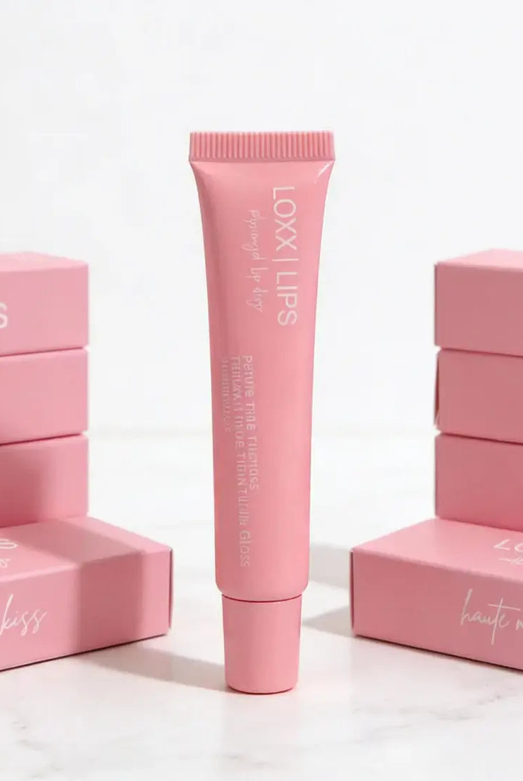 LOXX LIPS Peptide Lip Gloss Haute Mess Kiss Pink Tint packaging displayed, featuring a tube in front of pink boxes.