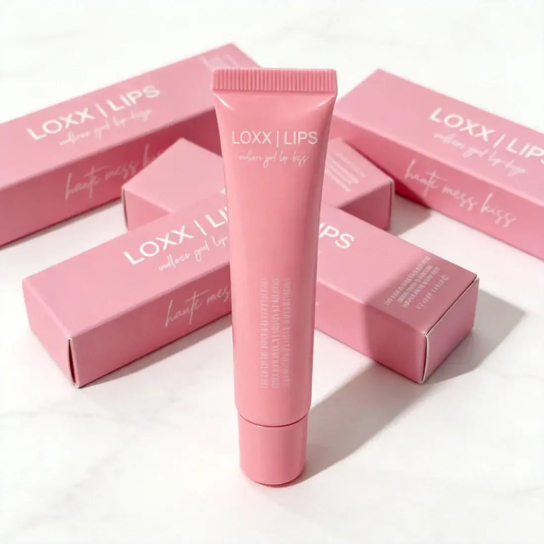 LOXX LIPS Peptide Lip Gloss Haute Mess Kiss Pink Tint packaging and product tube on display.