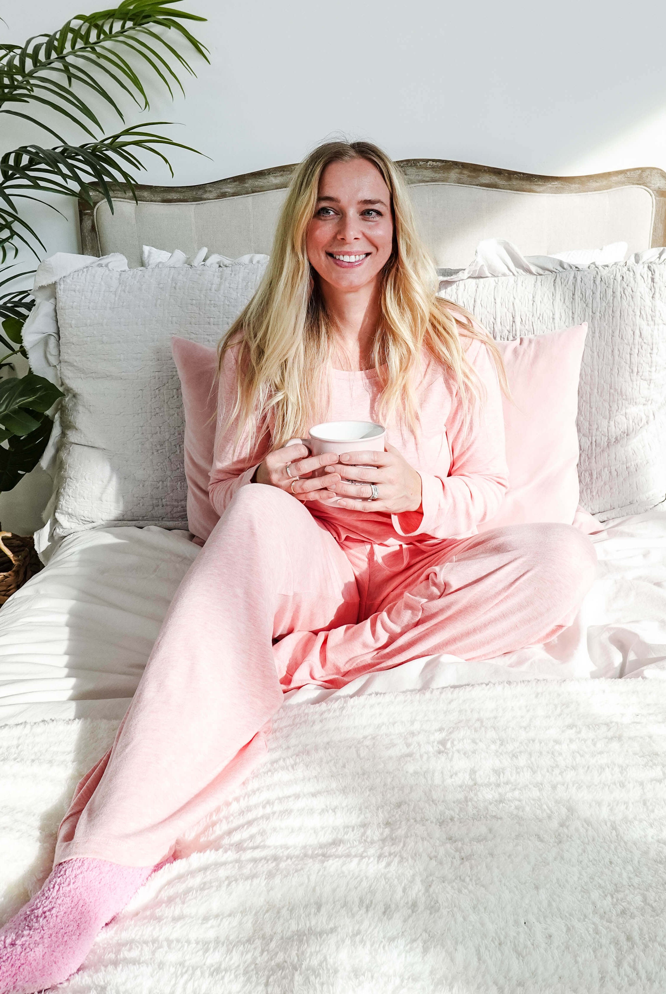 woman on bed wearing heather pink top straight pant lounge set