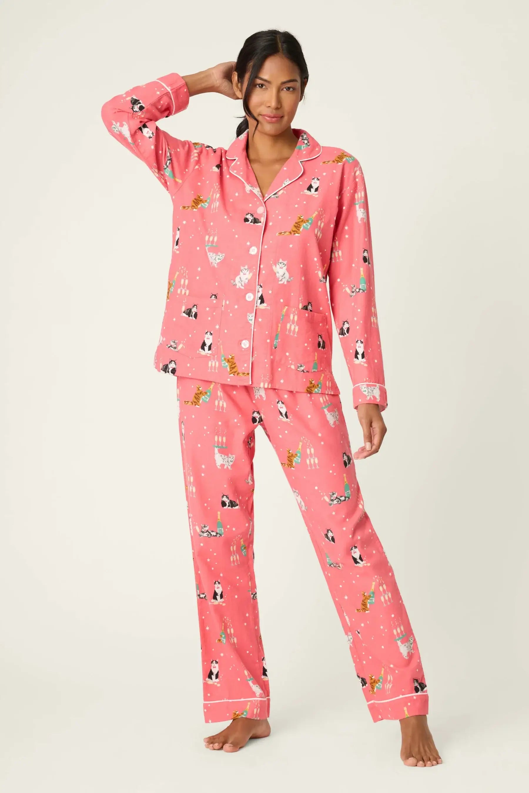 PJ Salvage "Let's Get Fizzical" 3-Piece Flannel PJ Set in dark coral with festive champagne-sipping cat print. She is wearing the button-front top, drawstring pants, and matching headband.