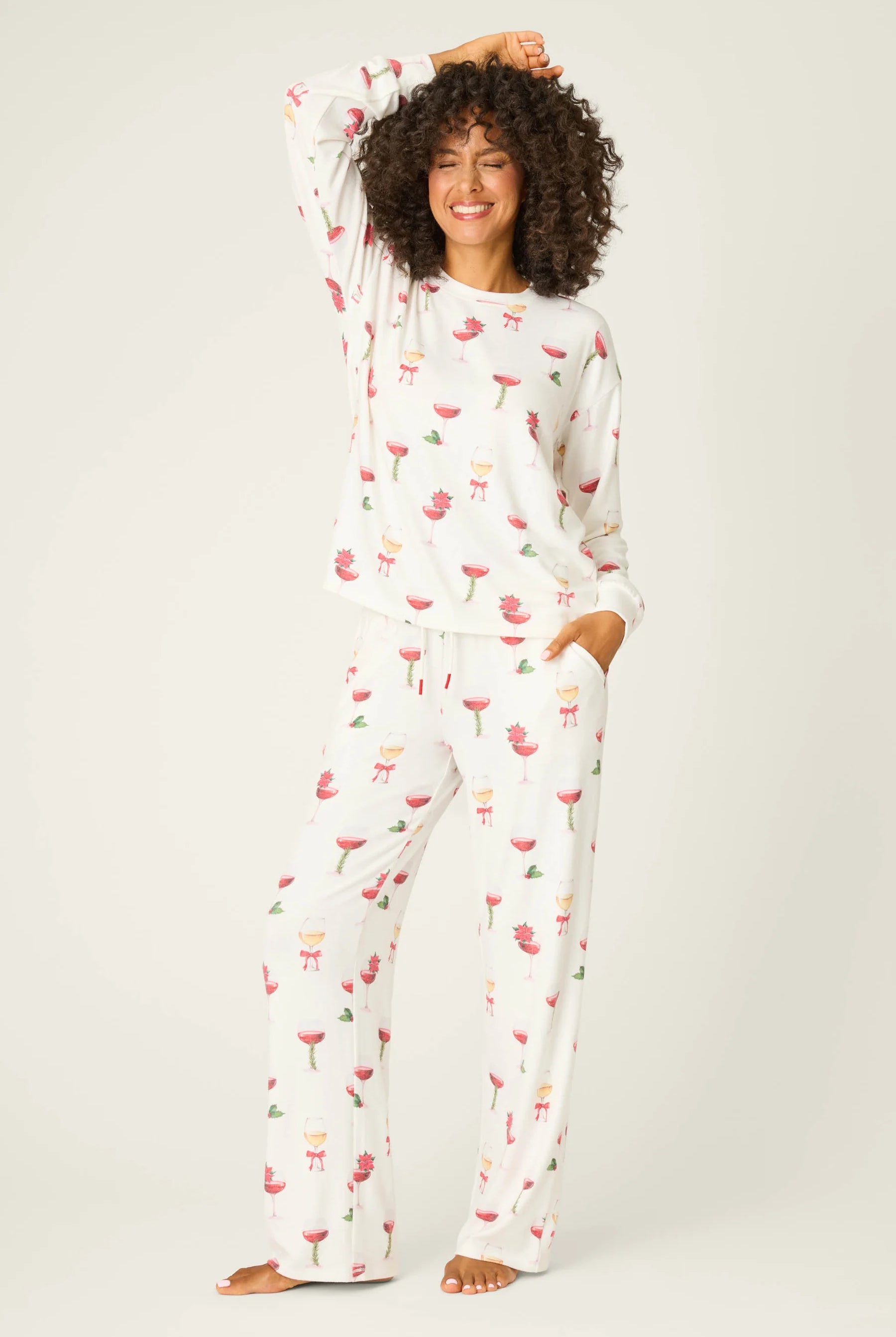 Let's Get Toasty Holiday Wine Print PJ Set | Champagne | PJ Salvage Women's set with champagne coupes with red liquid and holly, poinsettia and bows on an ivory background