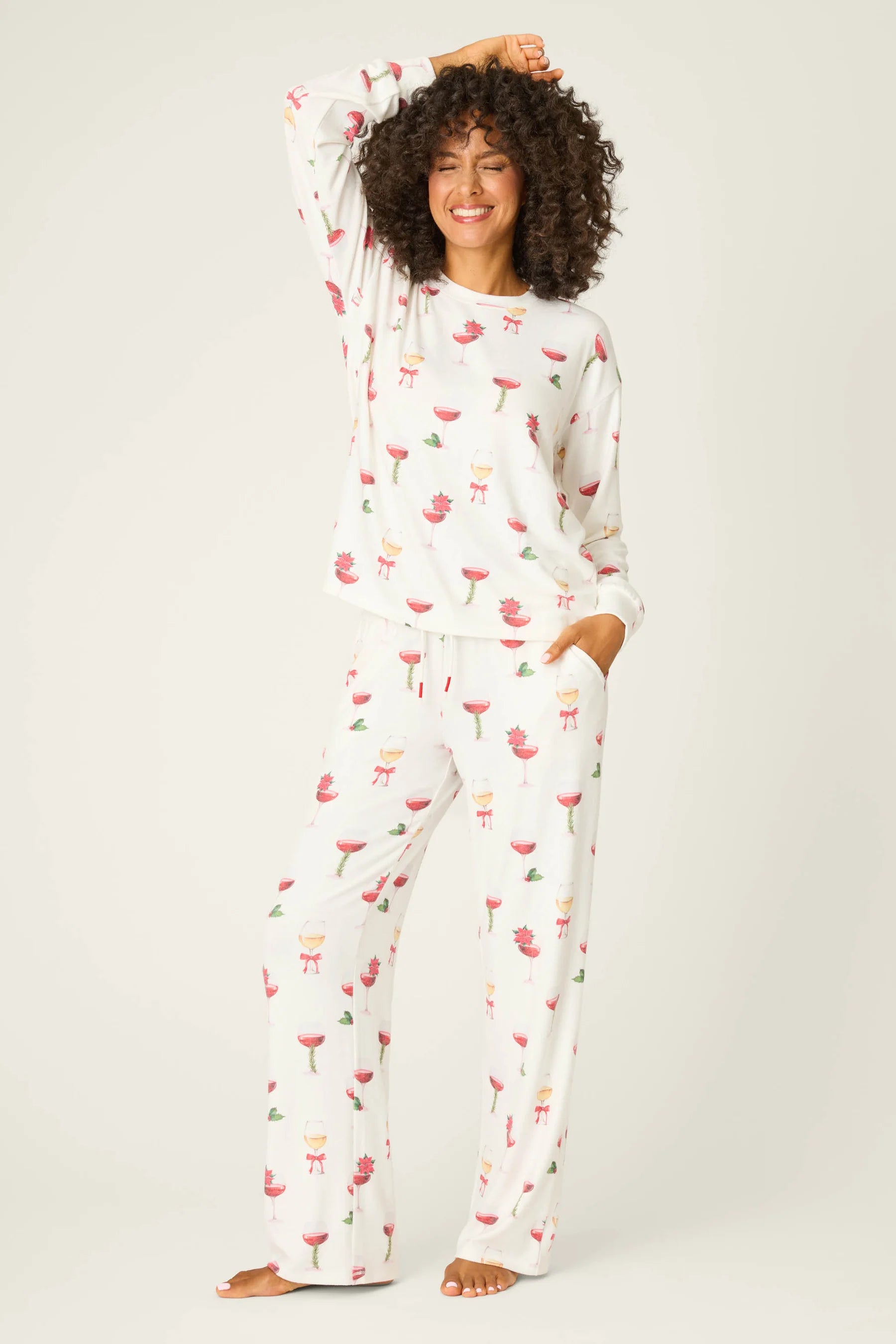 Let's Get Toasty Holiday Wine Print PJ Set | Champagne | PJ Salvage Women's set with champagne coupes with red liquid and holly, poinsettia and bows on an ivory background