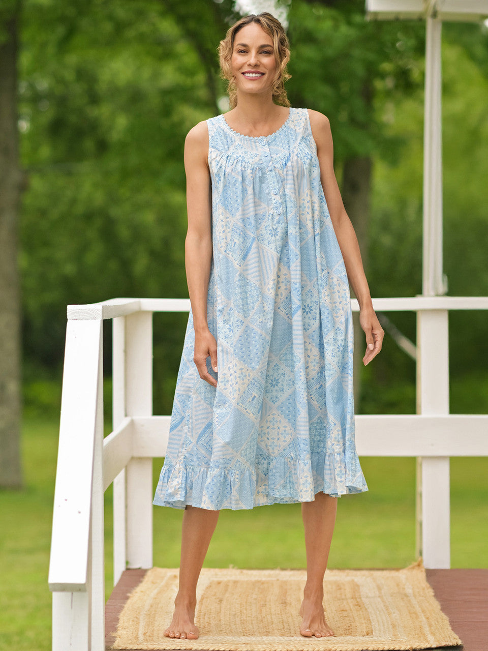 April Cornell Maddie’s Medley Cotton Nightgown – Embroidered Light Blue Sleeveless Nighty with Button Front. Worn by a model in a cottage/outdoor setting