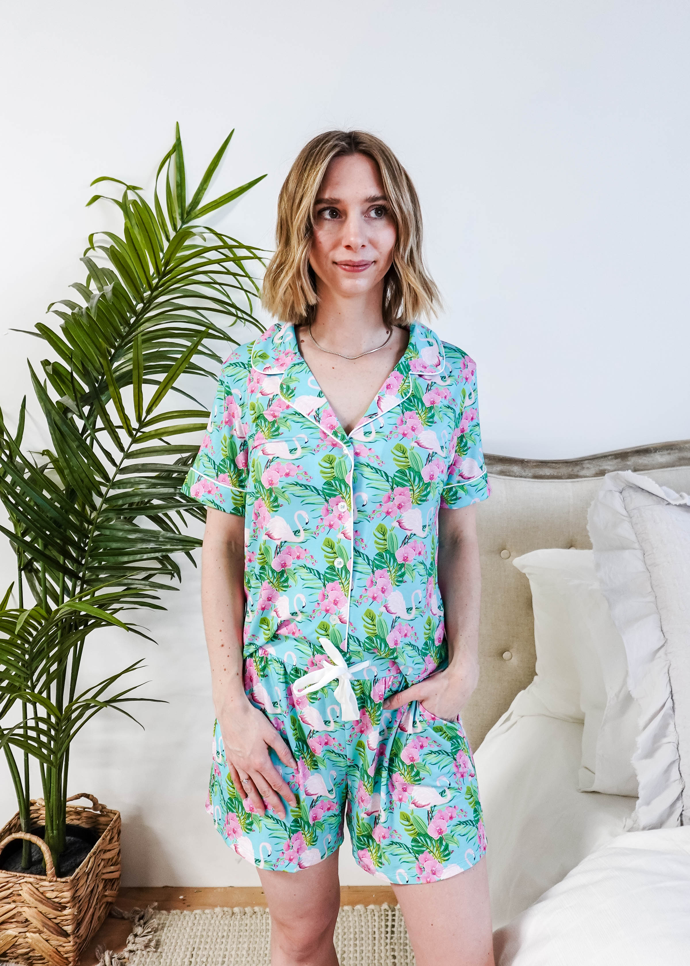 Model wearing Tropic Like It's Hot Bamboo Short Sleeve Pajama Set with pink flamingo and tropical orchid print.