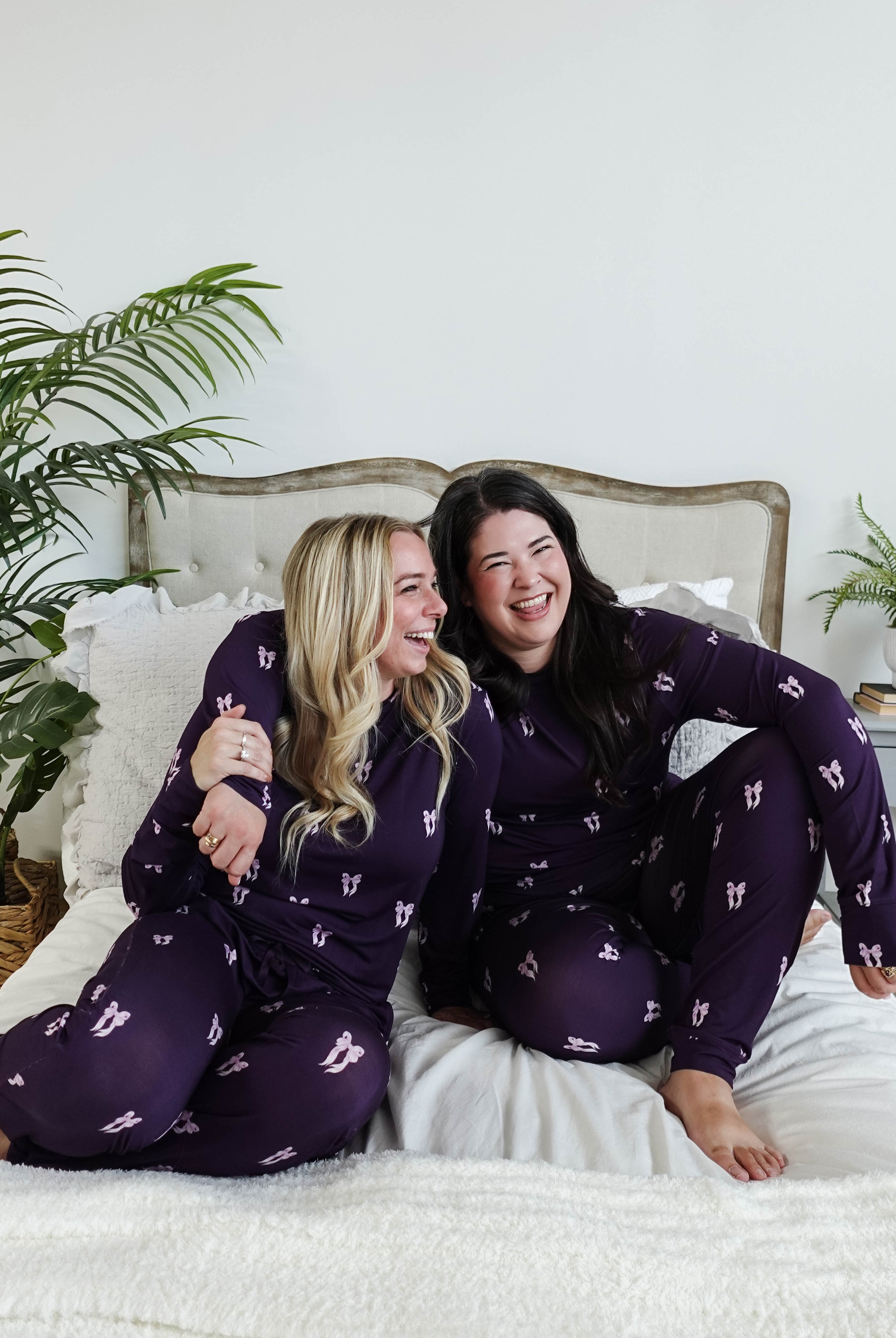 Purple Bows Print Long Sleeve & Jogger Bamboo PJ Set by Georgia Rylan, two models laughing on a plush bed showcasing the pyjama set