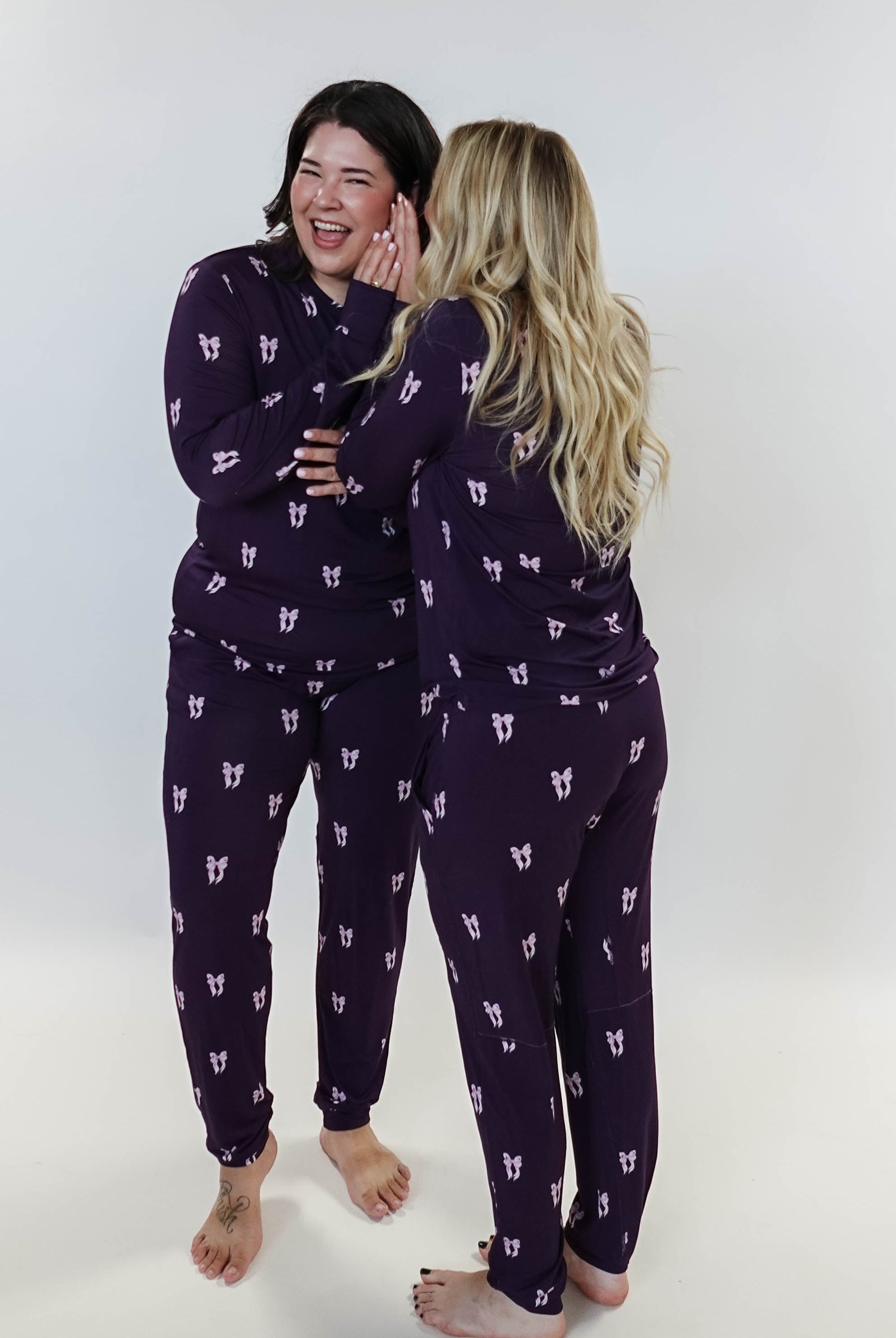 Purple Bows Print Long Sleeve & Jogger Bamboo PJ Set - two models on white background whispering a secret!