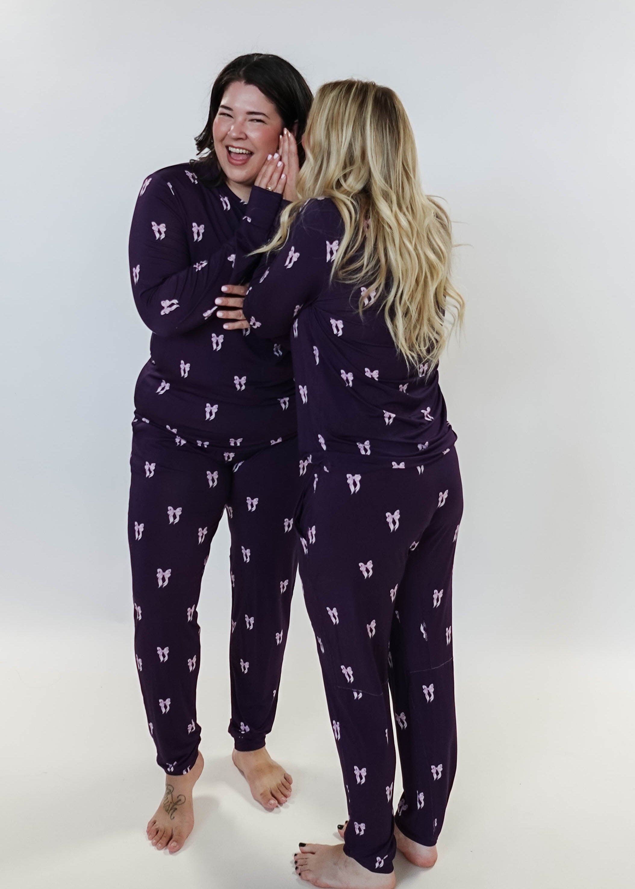 Purple Bows Print Long Sleeve & Jogger Bamboo PJ Set - two models on white background whispering a secret!