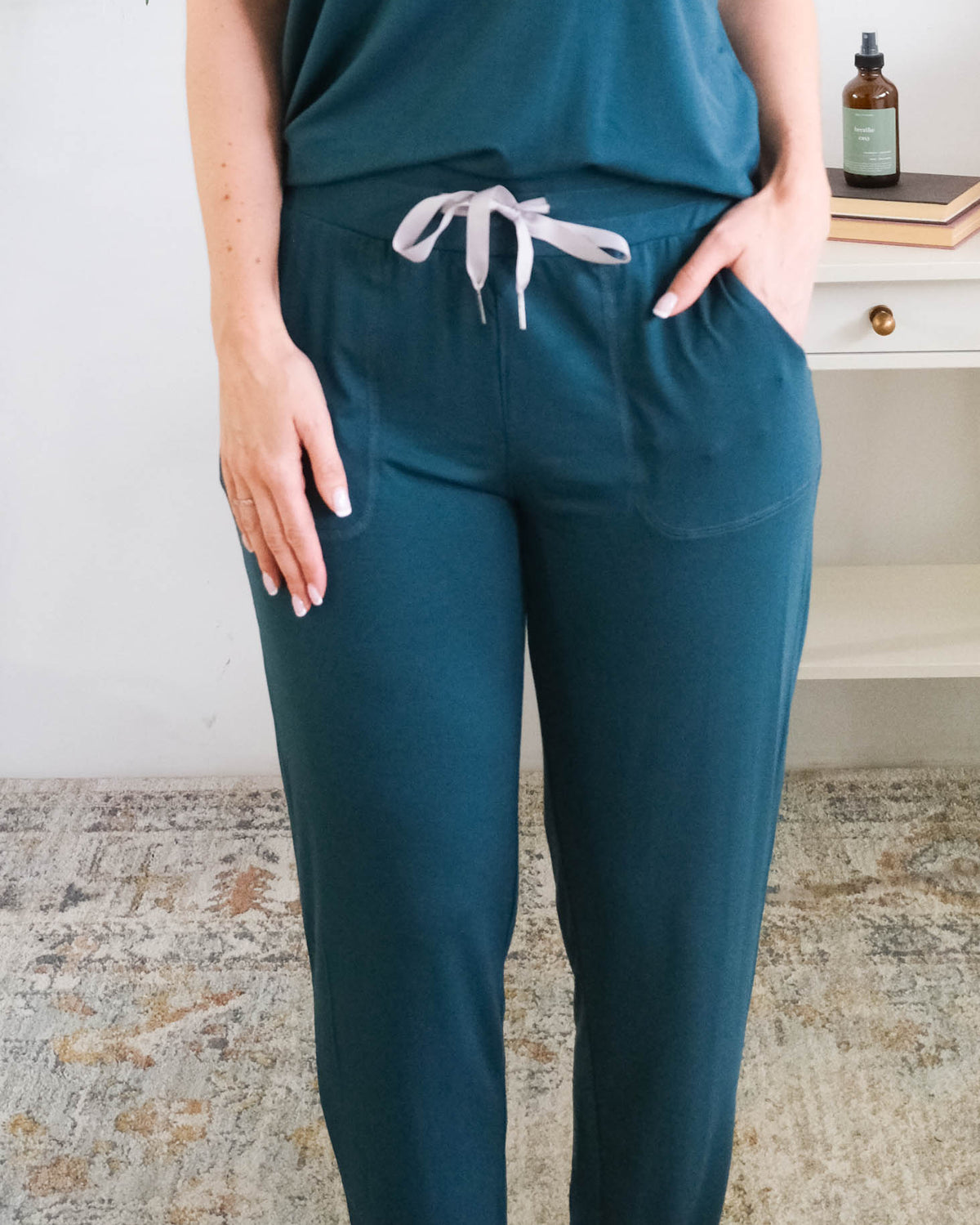 A person wearing dark teal pants with a grey ribbon drawstring and side pockets, the person is wearing the Pj Tee Jogger Midnight Teal Bamboo Pj Set. Cloud Nine Pajamas Edmonton