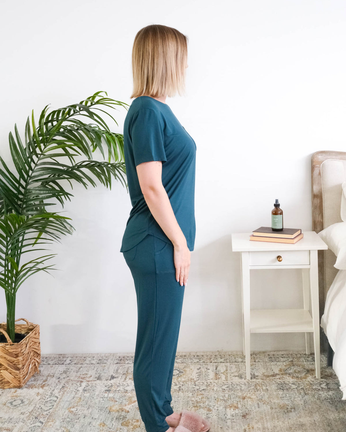 Side view of a woman standing wearing the Tee/Jogger PJ Set in Midnight Teal, showing the fit through the torso and jogger leg. Cloud Nine Pajamas Edmonton