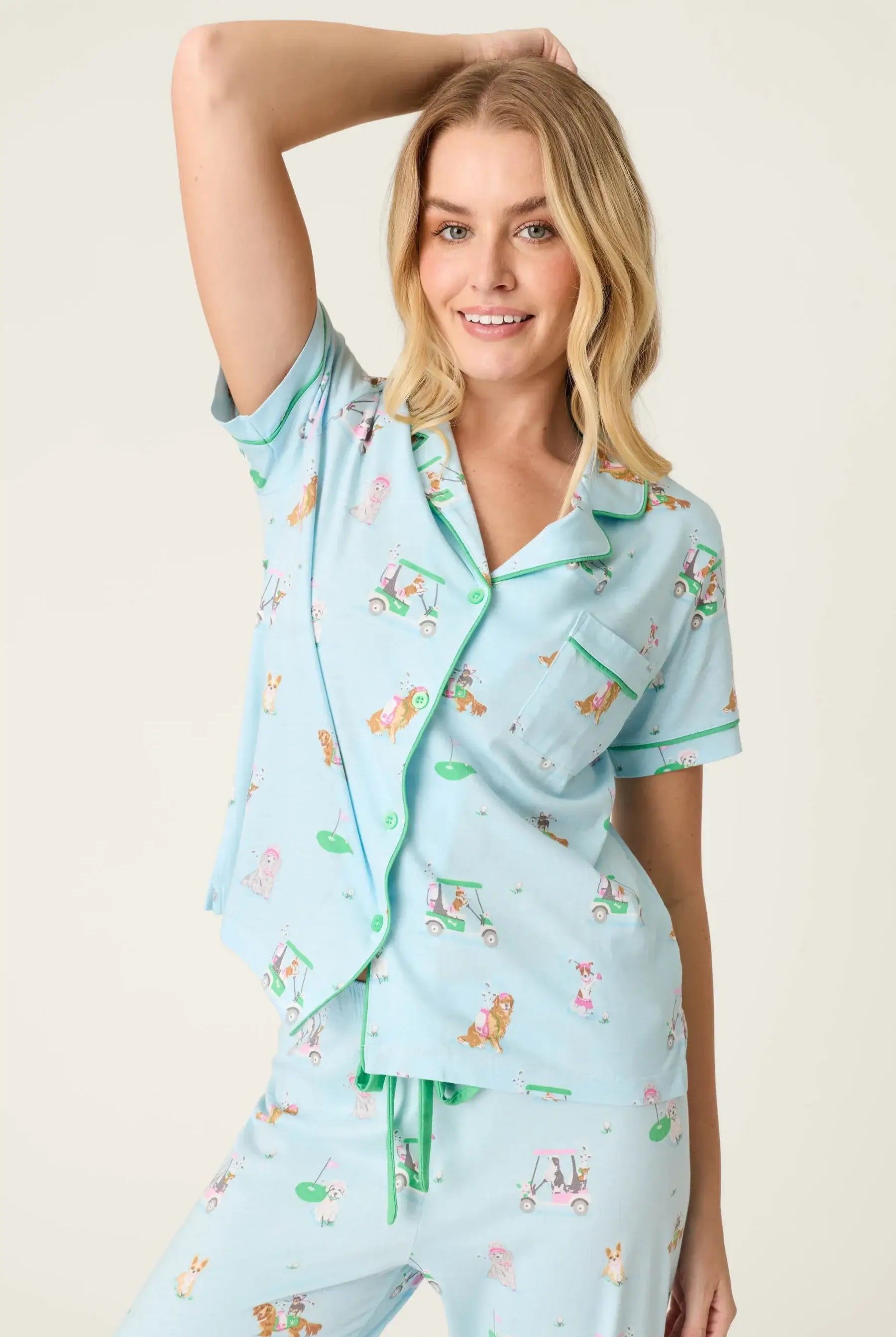 PJ SALVAGE Whimsy Cropped PJ Set in Light Blue Putter Pup print showing dogs golfing. Model stands wearing the set against a light background in a closeup of the top