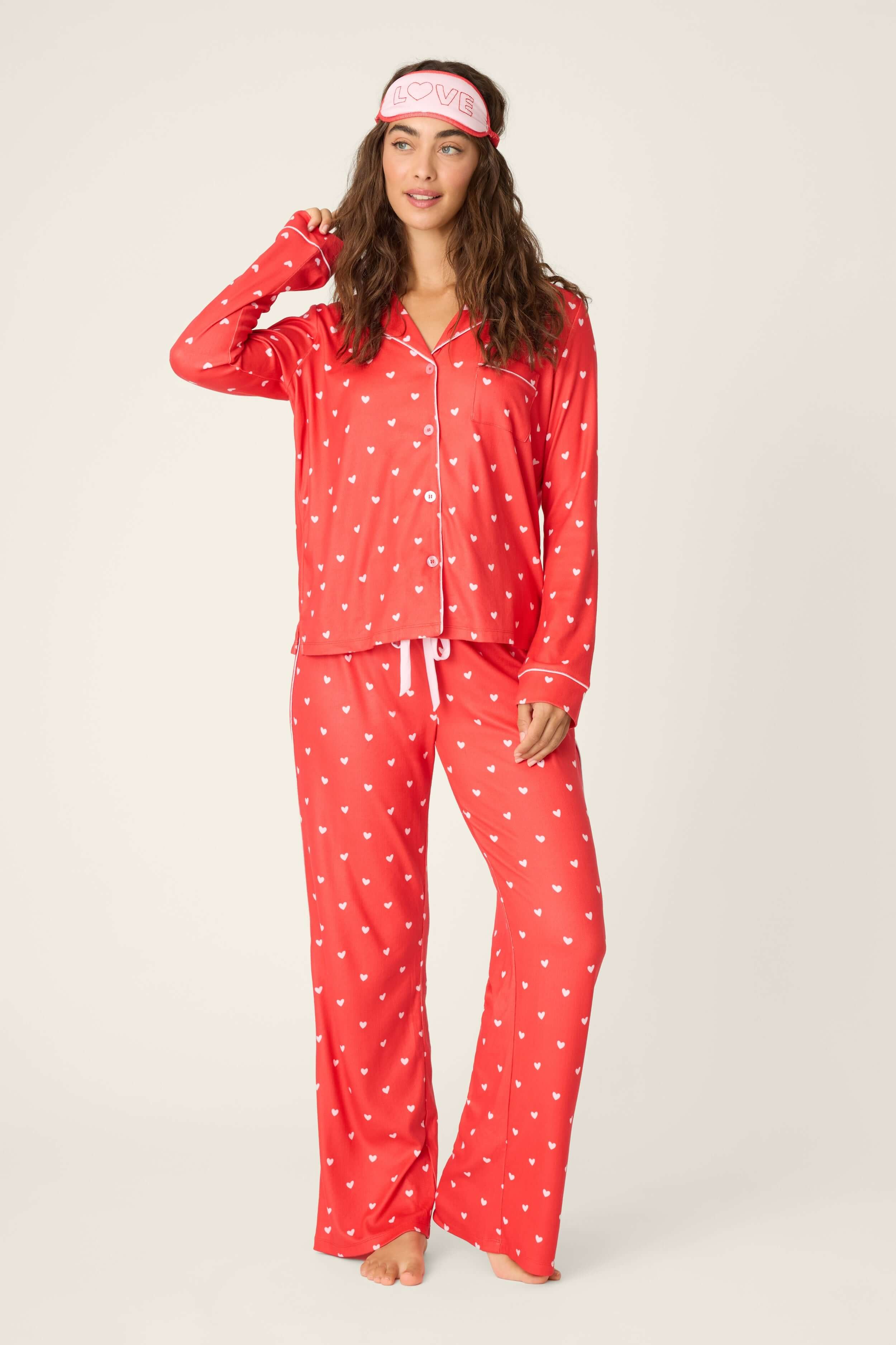 Model wearing Red Hearts Pointelle Button Up Pajama Gift Set with eyemask, showcasing vibrant red and pink hearts design.