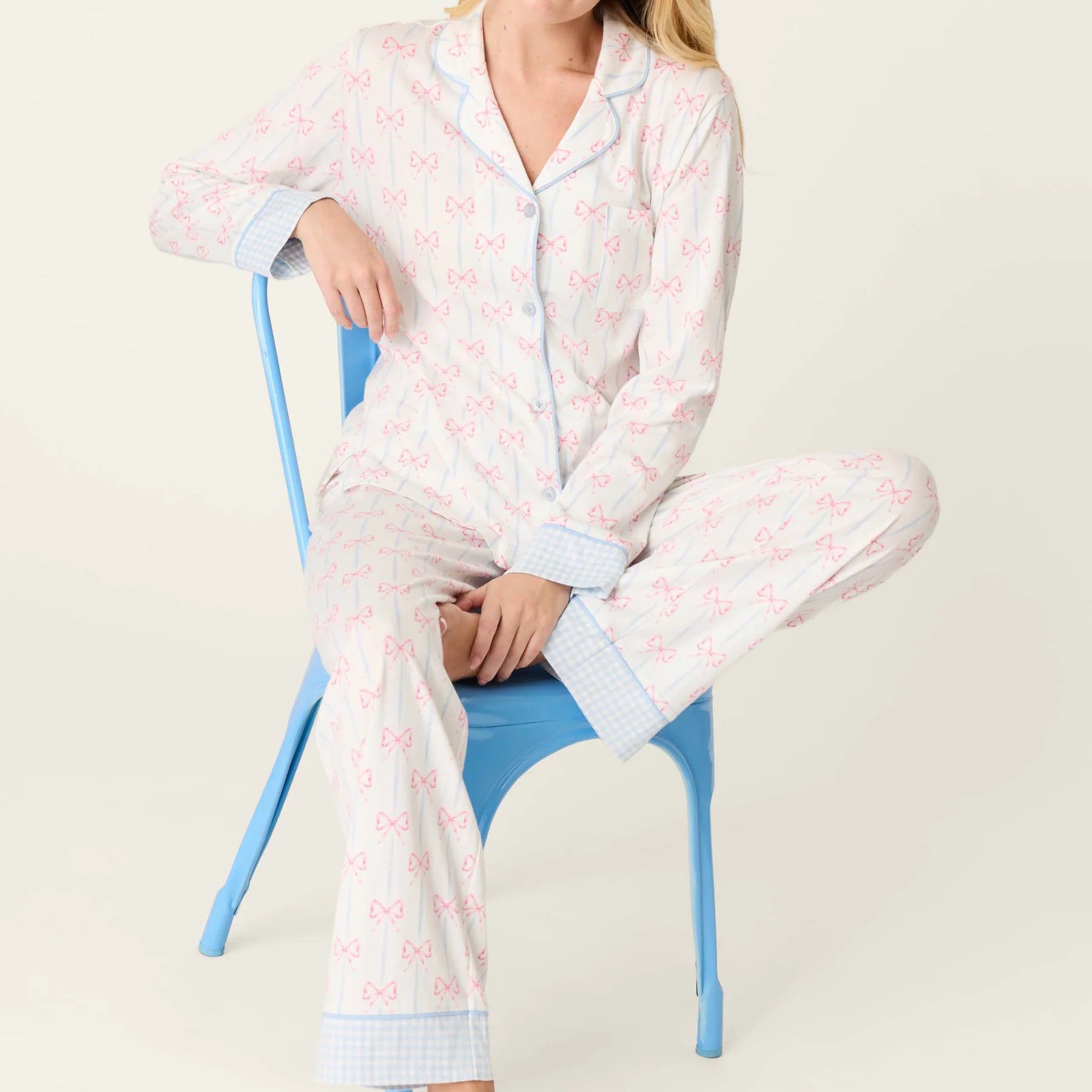 Model wearing Playful Prints Cotton-Modal Long Sleeve Pajama Set by PJ Salvage sitting on a blue chair.
