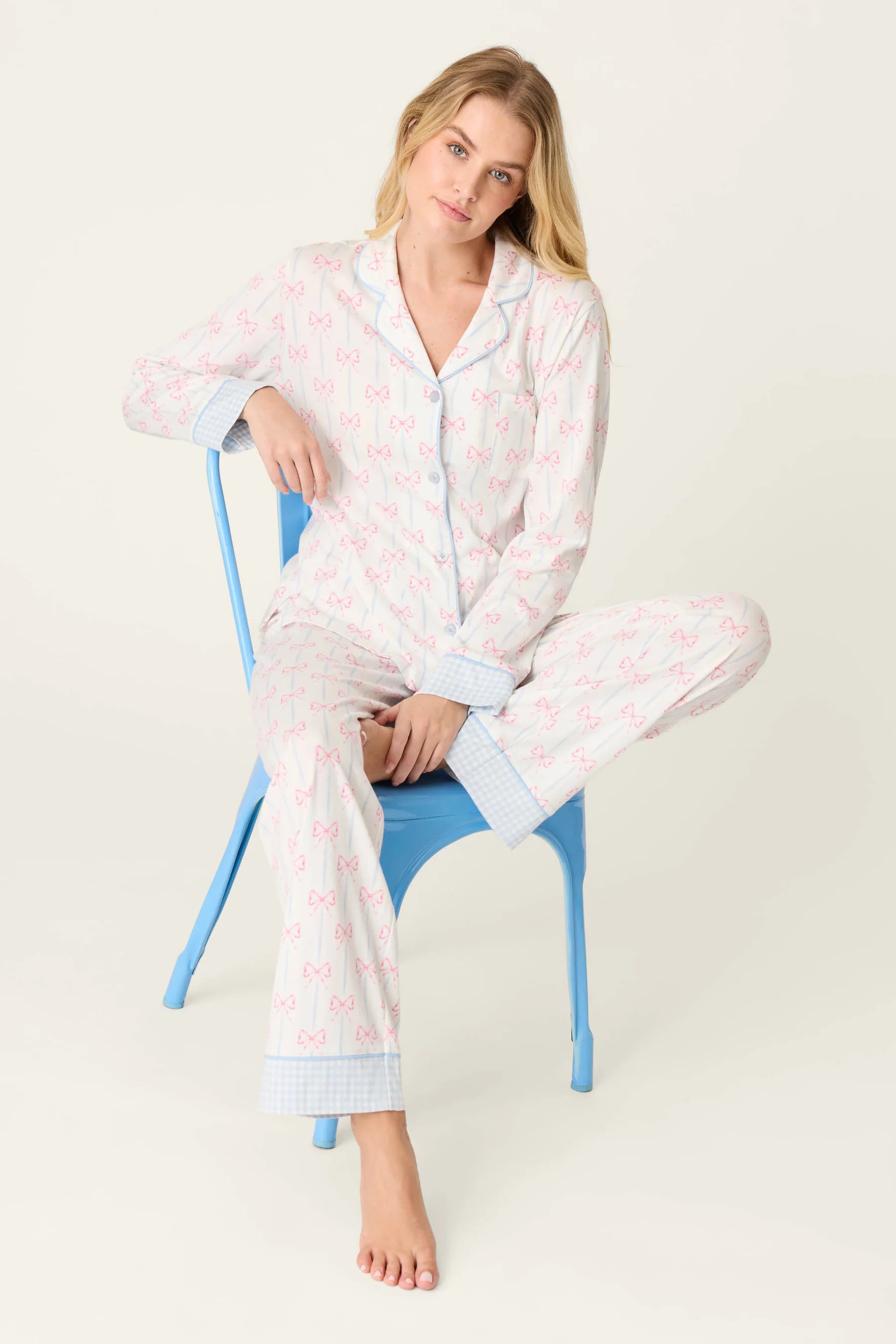 Model wearing Playful Prints Cotton-Modal Long Sleeve Pajama Set by PJ Salvage sitting on a blue chair.