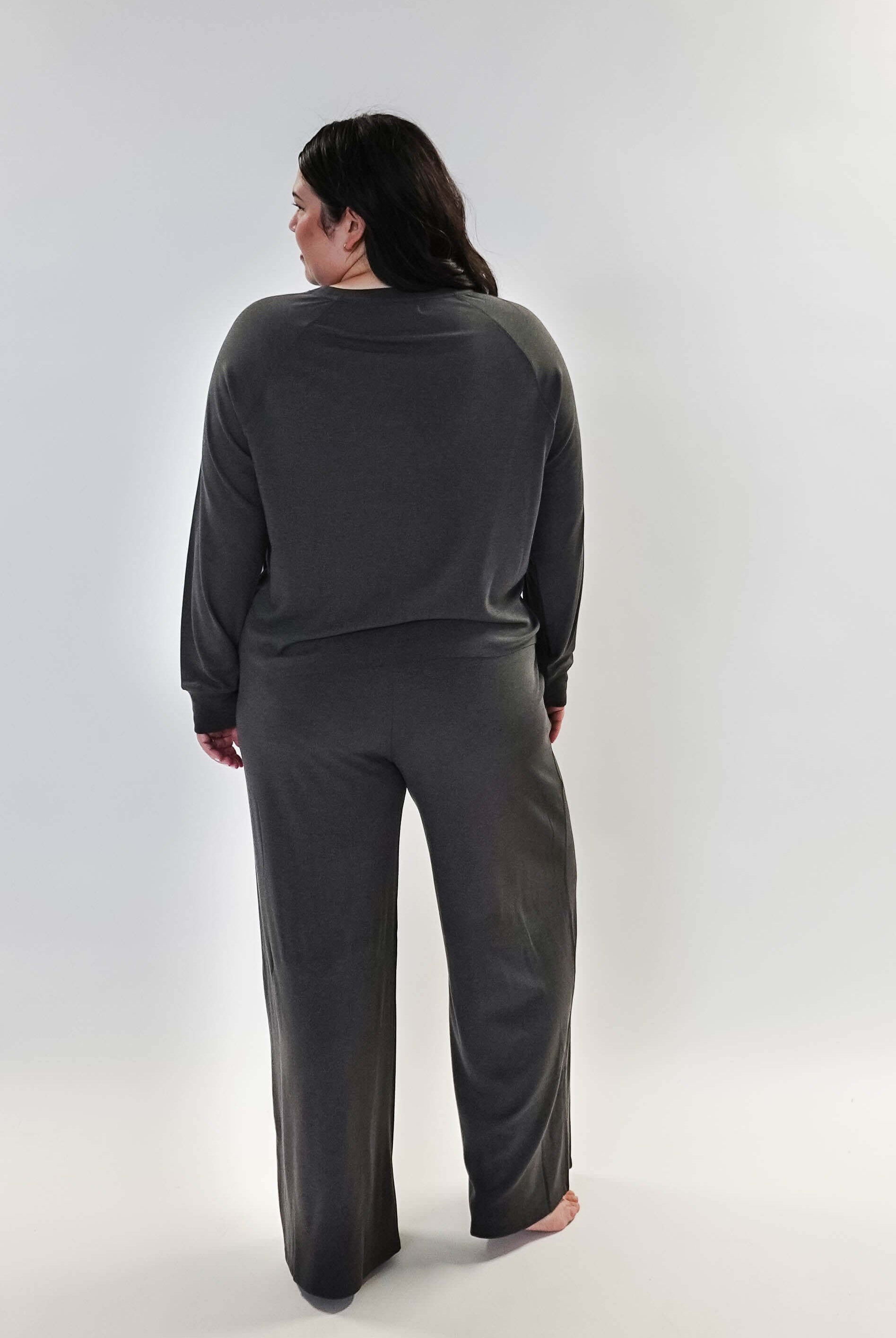 Woman wearing Long Sleeve Raw Edge Straight Pant Lounge Set, viewed from behind, showcasing the relaxed fit and stylish design.