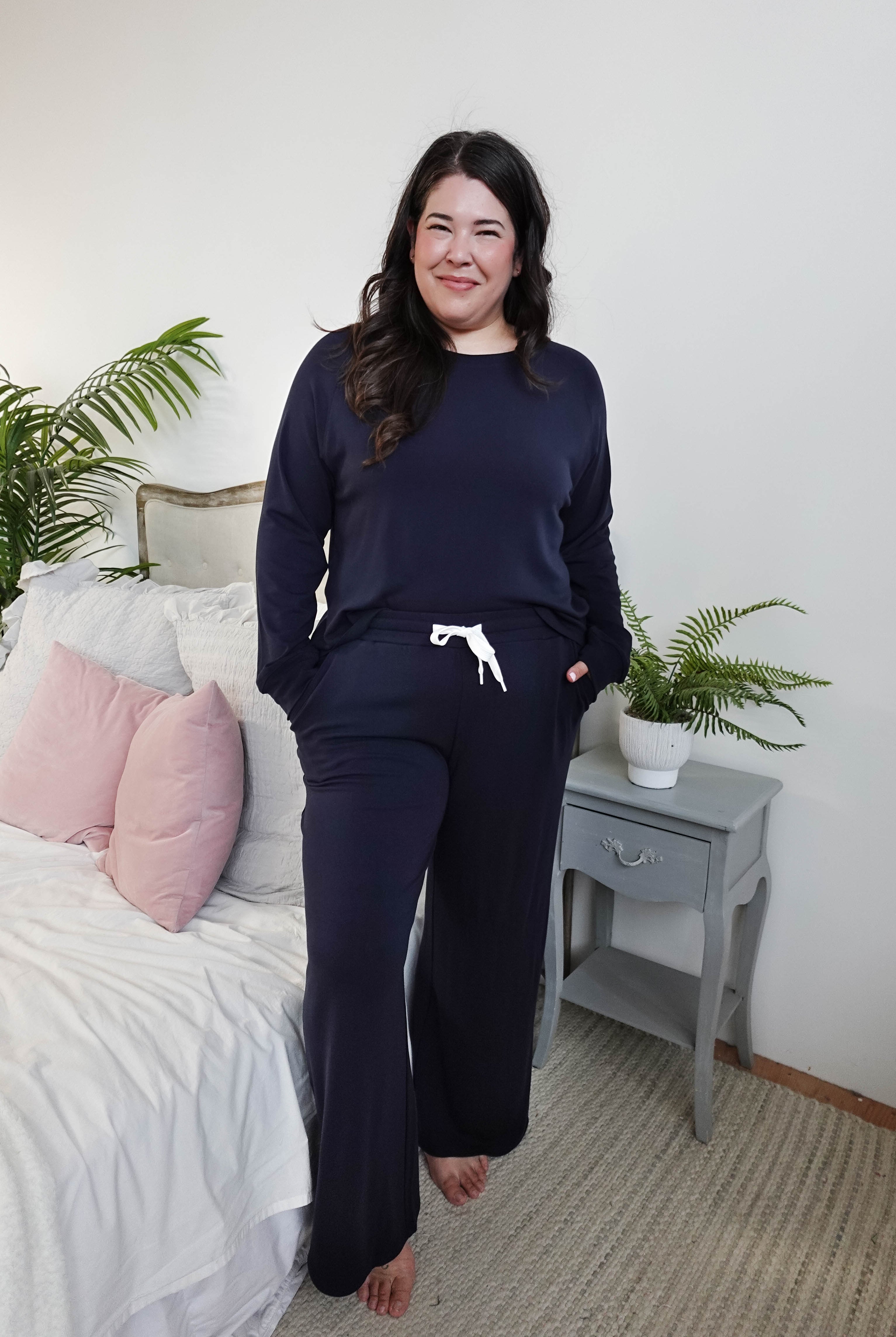 Model wearing Long Sleeve Raw Edge Straight Pant Lounge Set in navy color, posing in a cozy bedroom setting.