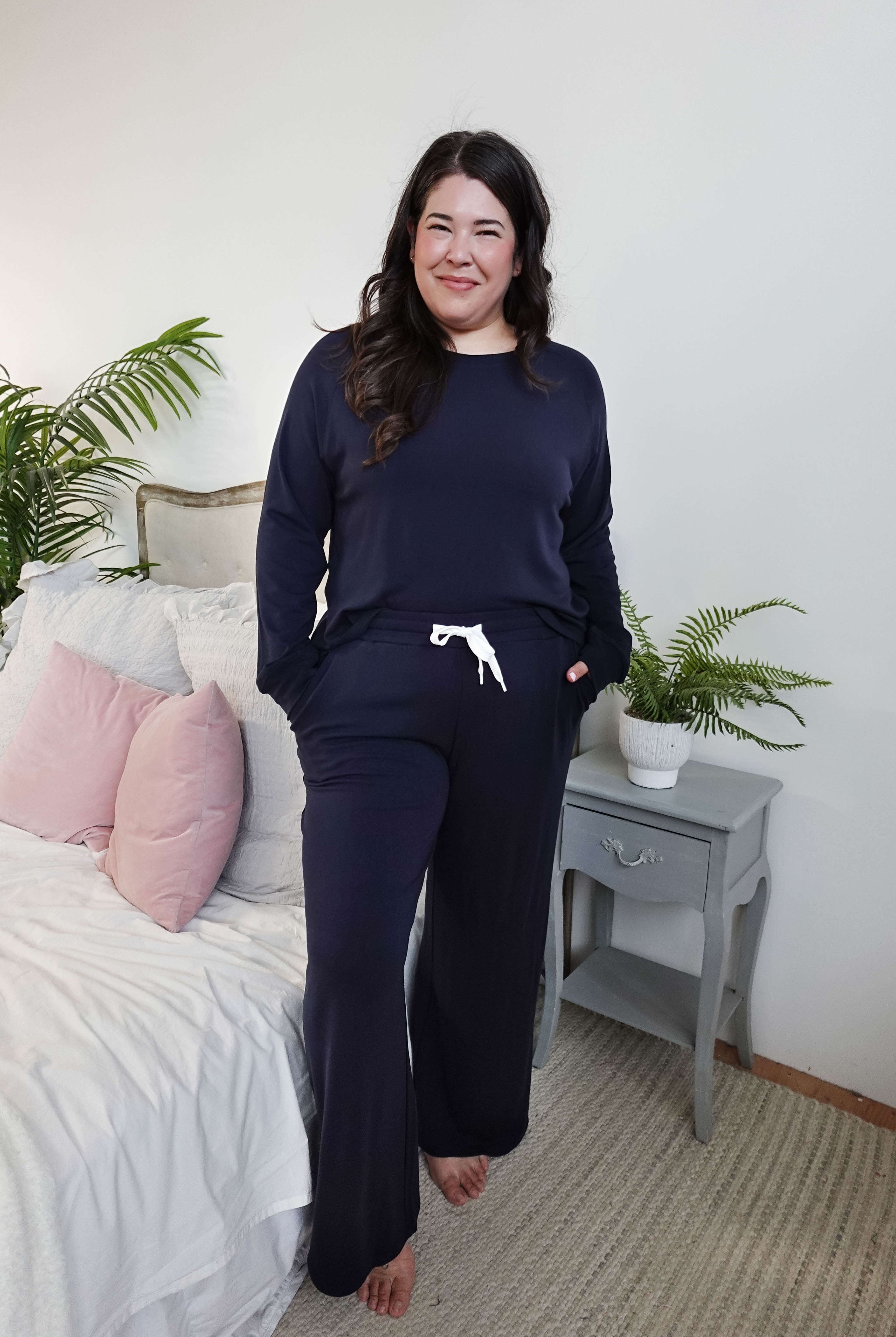 Model wearing Long Sleeve Raw Edge Straight Pant Lounge Set in navy color, posing in a cozy bedroom setting.