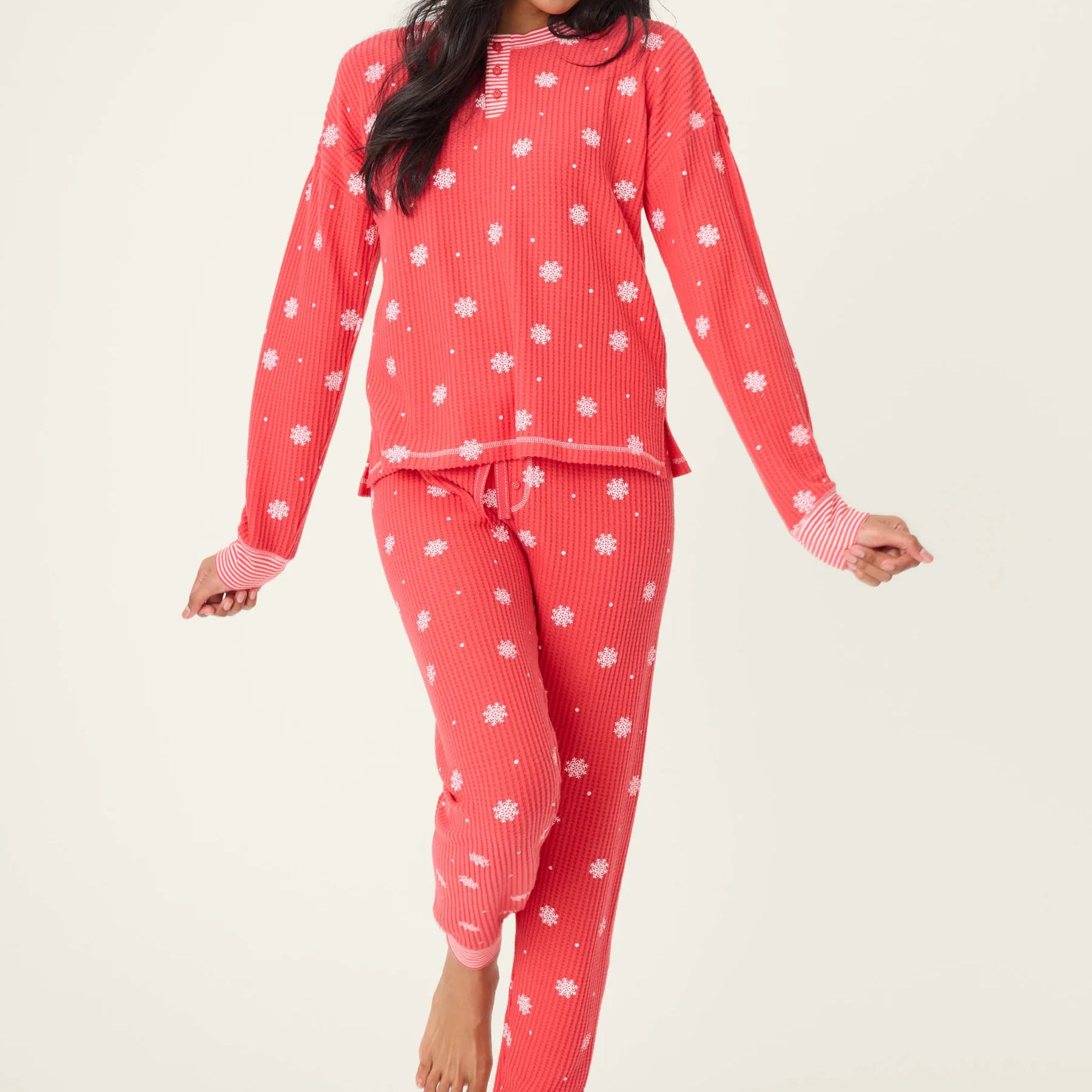 Woman wearing Ski Jammie Classics Brushed Thermal PJ Set, featuring playful winter prints in red and pink.