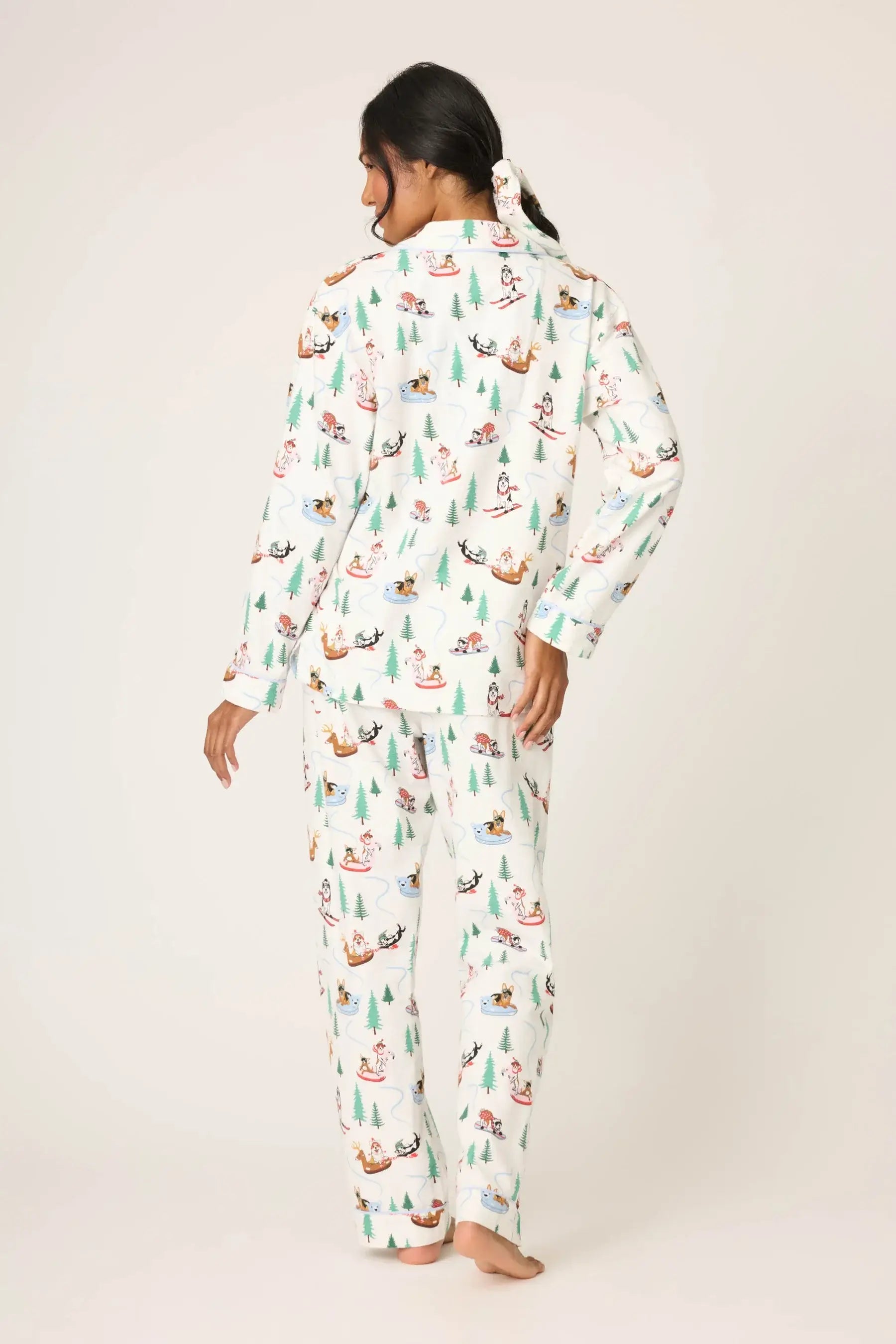 Woman wearing the Sleigh All Day Flannel 3-Piece PJ Set featuring fun dog prints and a winter-white backdrop.