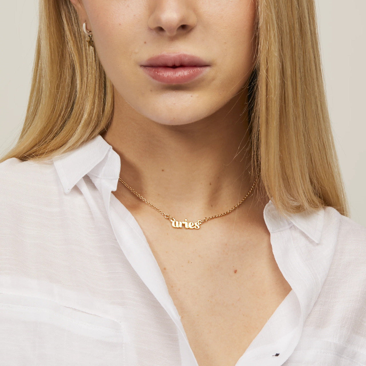 Zodiac Script Necklace in 14K Plated Gold featuring the Pisces astrological sign on a bright yellow display card.