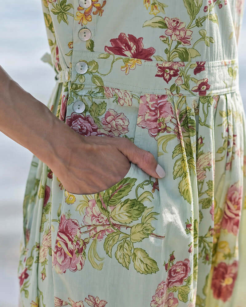 April Cornell Milene Cotton Pinafore Midi Dress Sage Green with Hand-Crochet Neckline showing the pockets and side button details