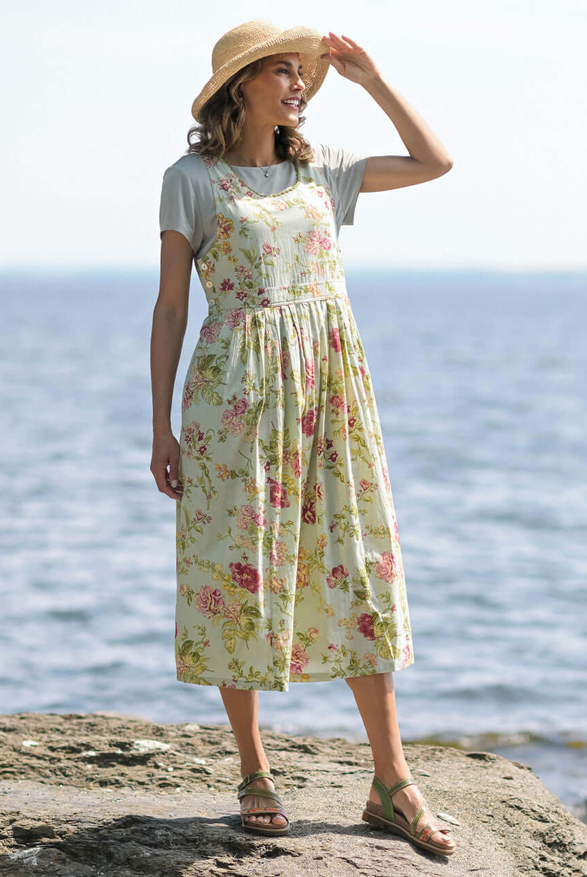 April Cornell Milene Cotton Pinafore Midi Dress Sage Green with Hand-Crochet Neckline model show on a rocky beach