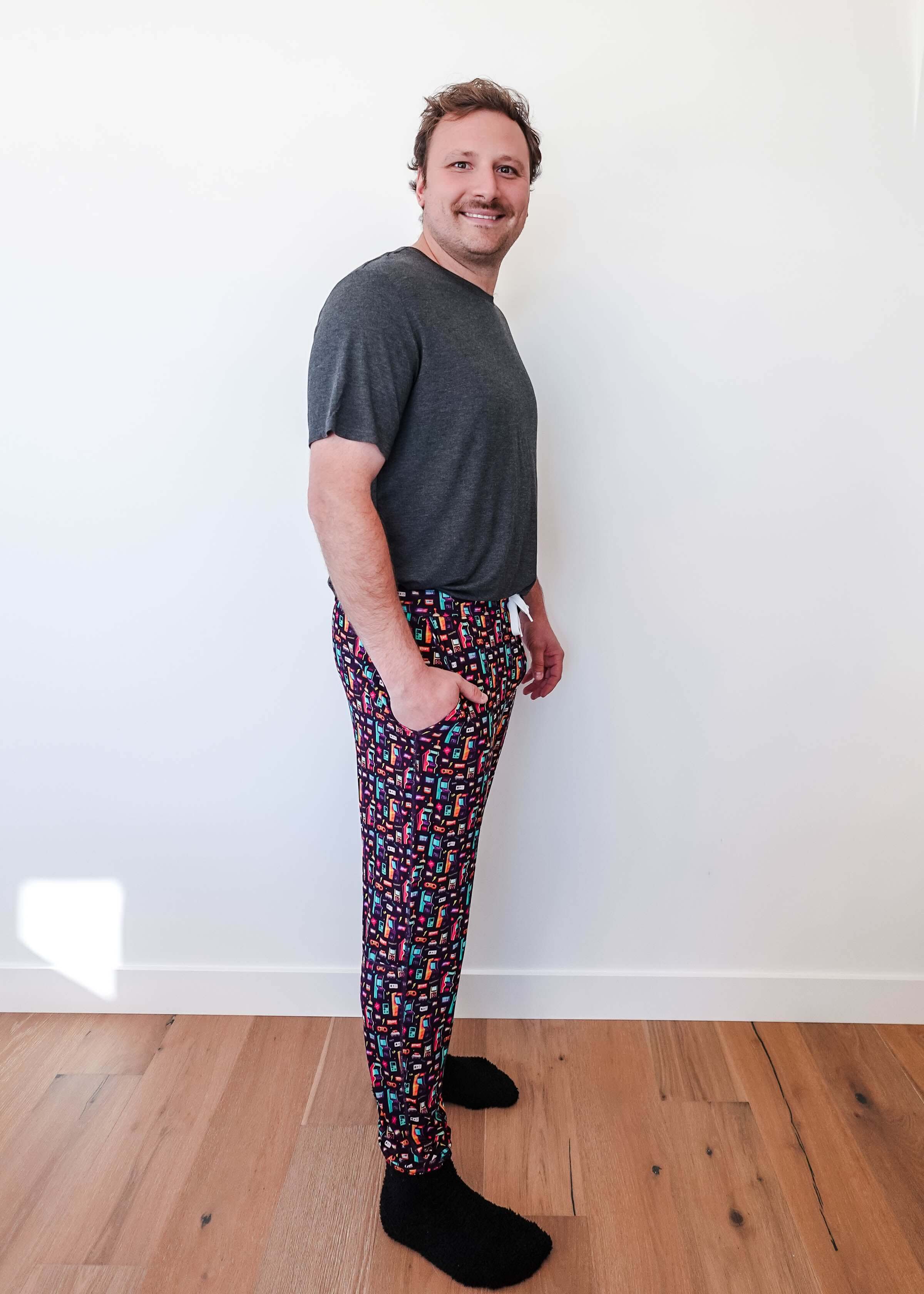 Man wearing Arcade After Dark Unisex Bamboo Jogger with graphic design, paired with a gray t-shirt, and socks.