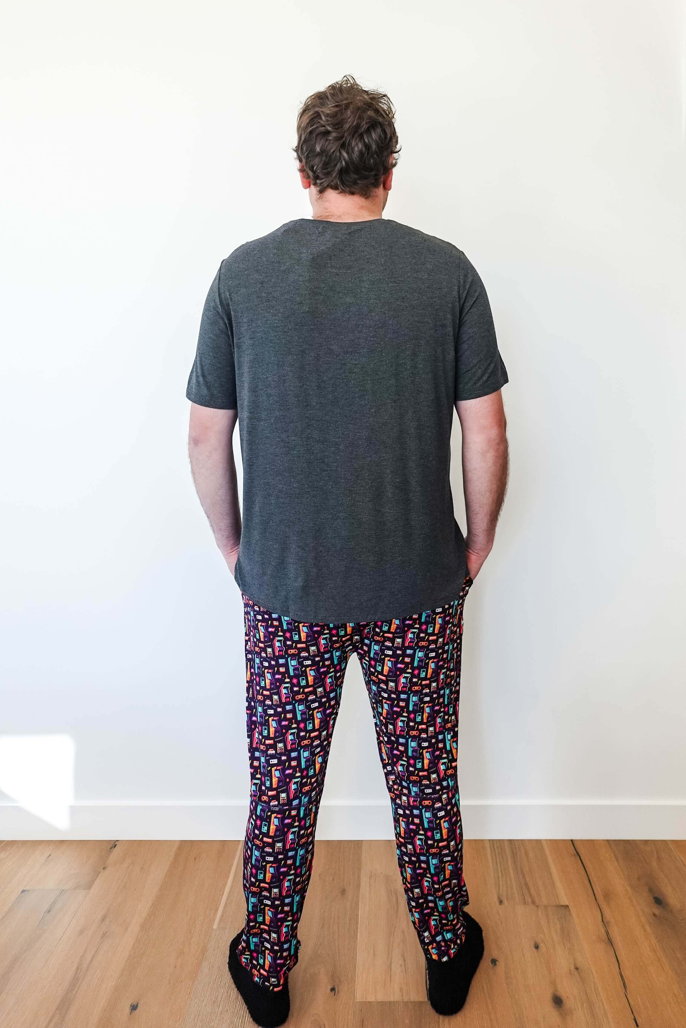 Man wearing Arcade After Dark Unisex Bamboo Jogger with graphic design, paired with a gray t-shirt, and socks.