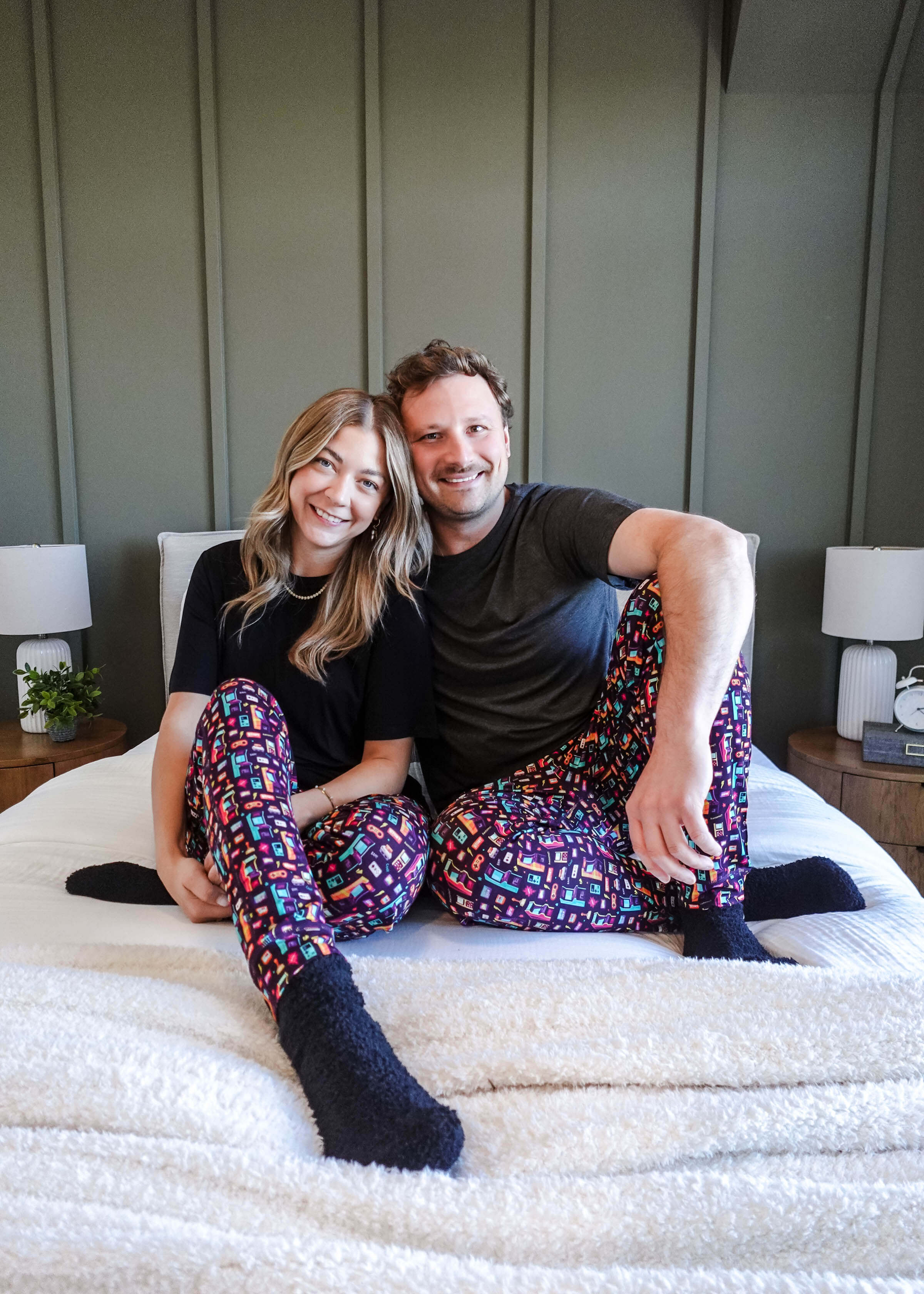 Couple wearing Arcade After Dark Unisex Bamboo Jogger on a bed, showcasing a fun and cozy loungewear style.