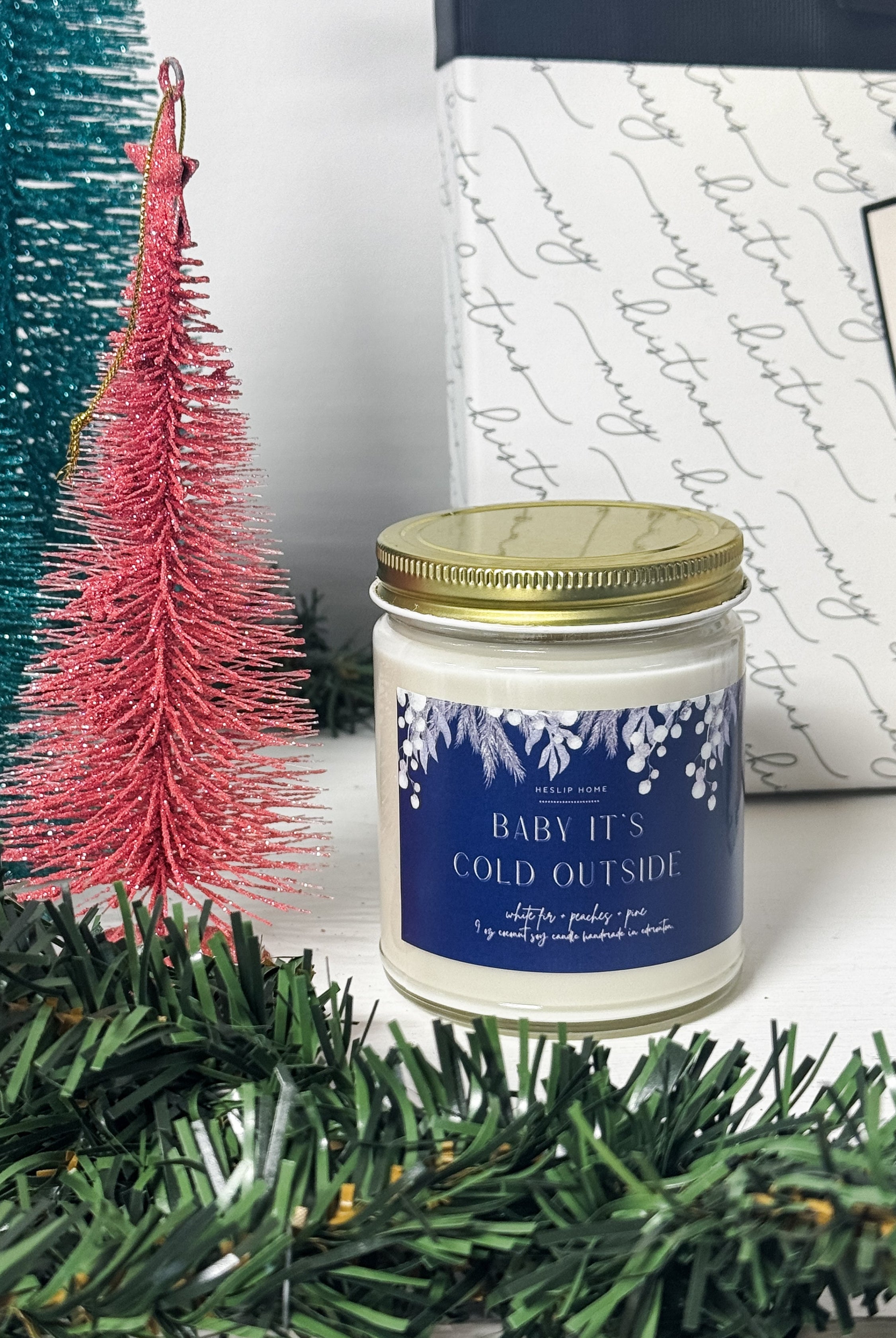baby its cold outside candle with notes of the woods - fir and pine - plus sweet peaches
