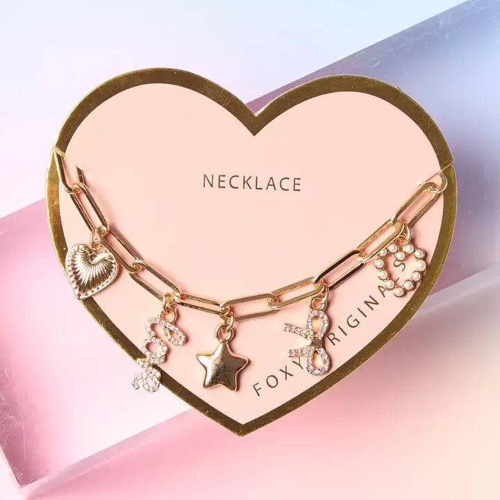 Bella Charm Necklace in 14K Gold featuring heart, star, bow, love script, and pearl charms on a gold chain.