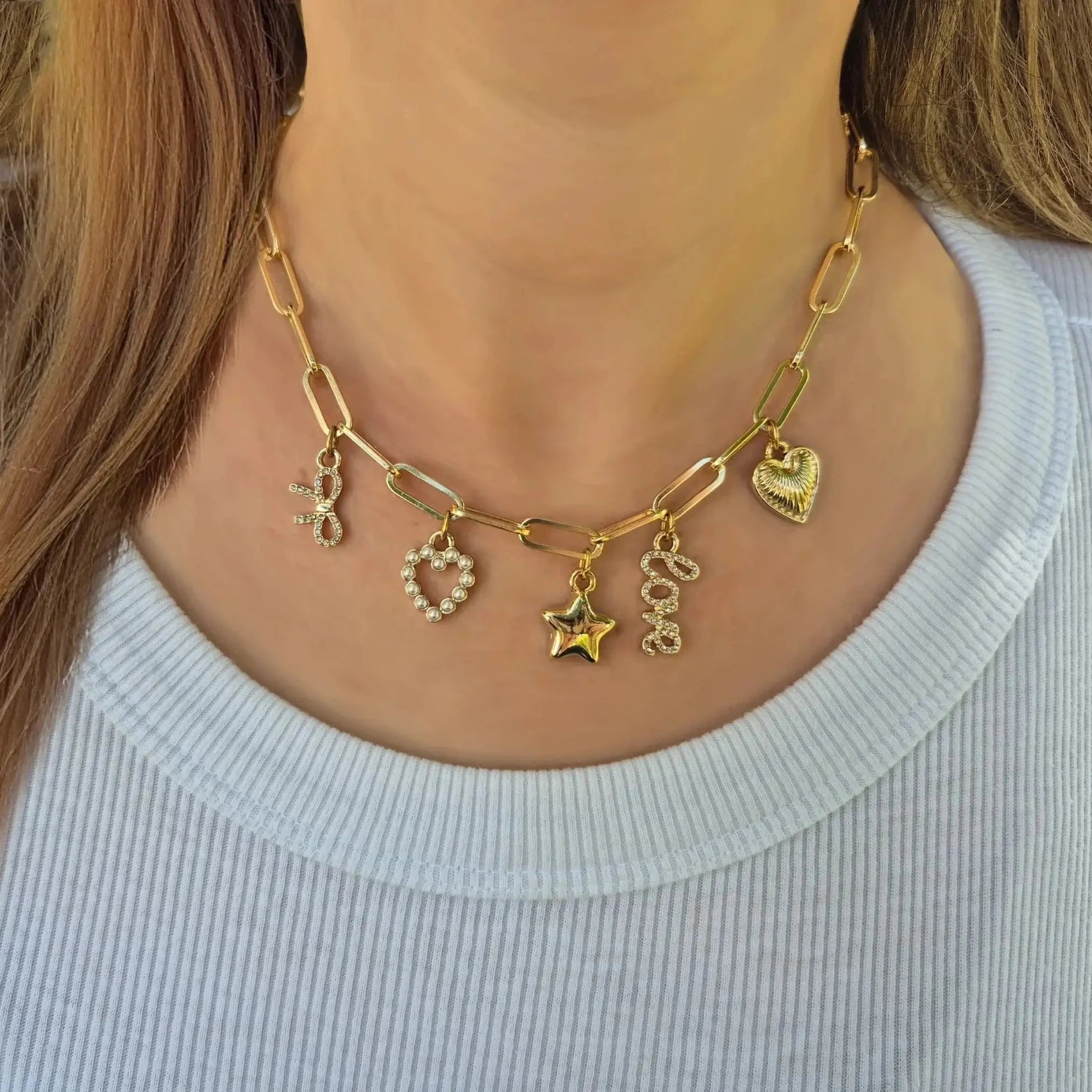 Bella Charm Necklace in 14K Gold featuring five charms: heart, star, bow, love script, and pearl heart.