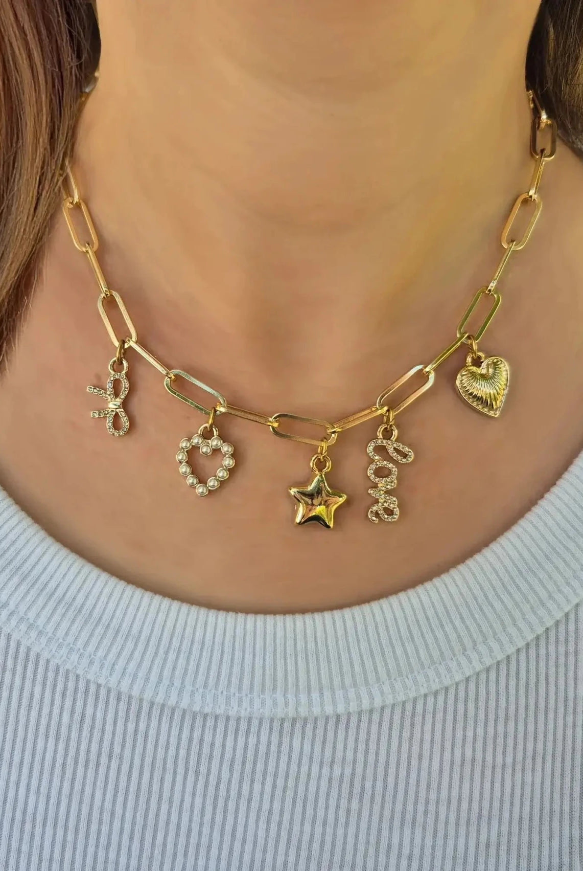 Bella Charm Necklace in 14K Gold featuring five charms: heart, star, bow, love script, and pearl heart.