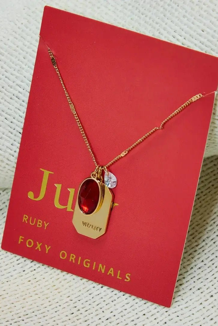 Birthstone Charm Necklace in 14k Plated Gold featuring a ruby stone, labeled 'Vitality', by Foxy Originals. Birthstone Charm Necklace in 14k Plated Gold for JUNE featuring a ruby stone, labeled 'Vitality', by Foxy Originals.