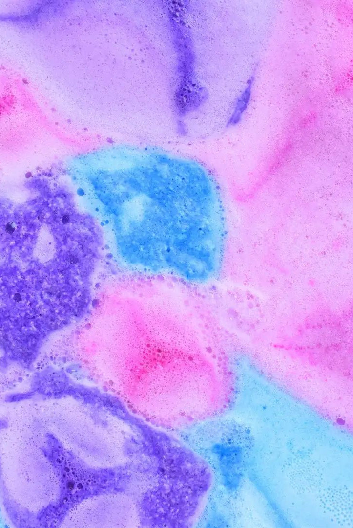 Vibrantly colored bath water created by Black Raspberry Vanilla Bath Bomb Crumble, showcasing pink, blue, and purple swirls.