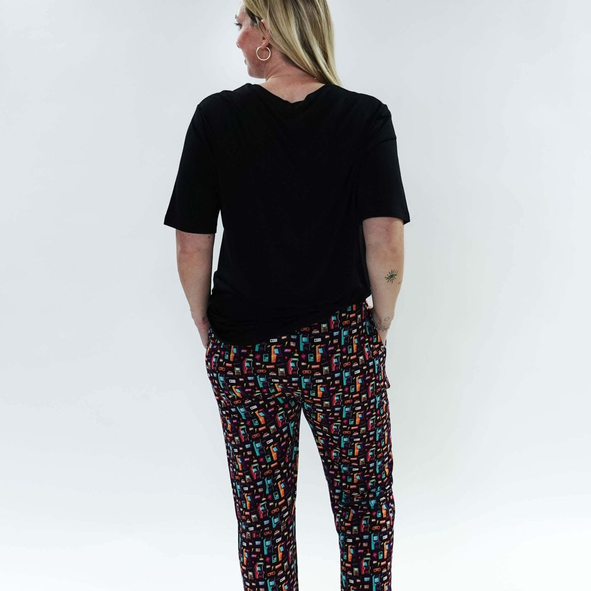 Woman wearing Arcade After Dark Unisex Bamboo Jogger from Bob's Sleepwear Co., showcasing a colorful design.